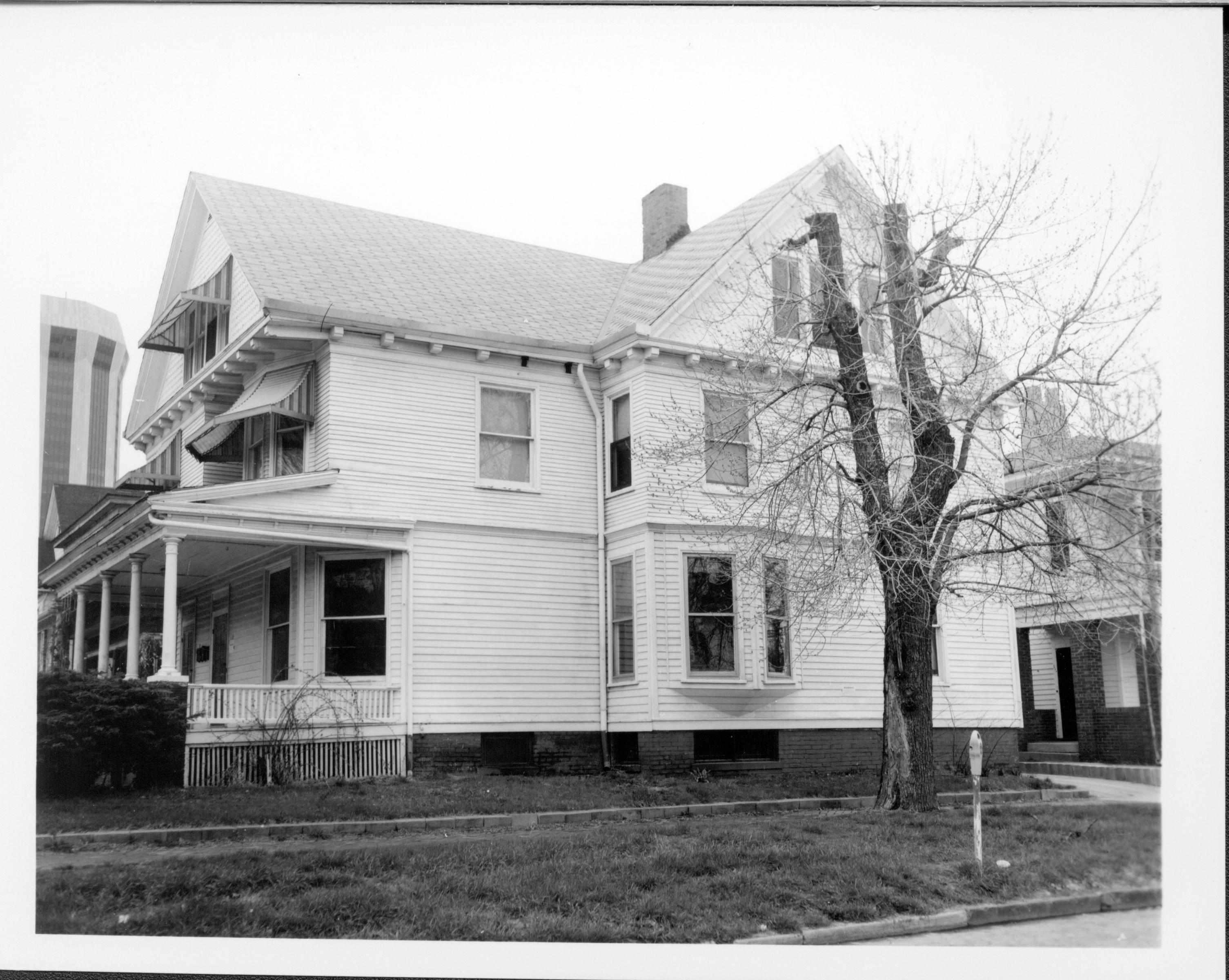 Home owned by William Hermes in use as apartments, South elevation along Jackson Street, Block 7, Lot 8.  Hilton hotel tower on left, home owned by William T. Sheeham on right. Visitor Center in location now.  Looking Northeast along Jackson Street Hermes, Sheeham, Hilton Hotel, Jackson Street, Visitor Center