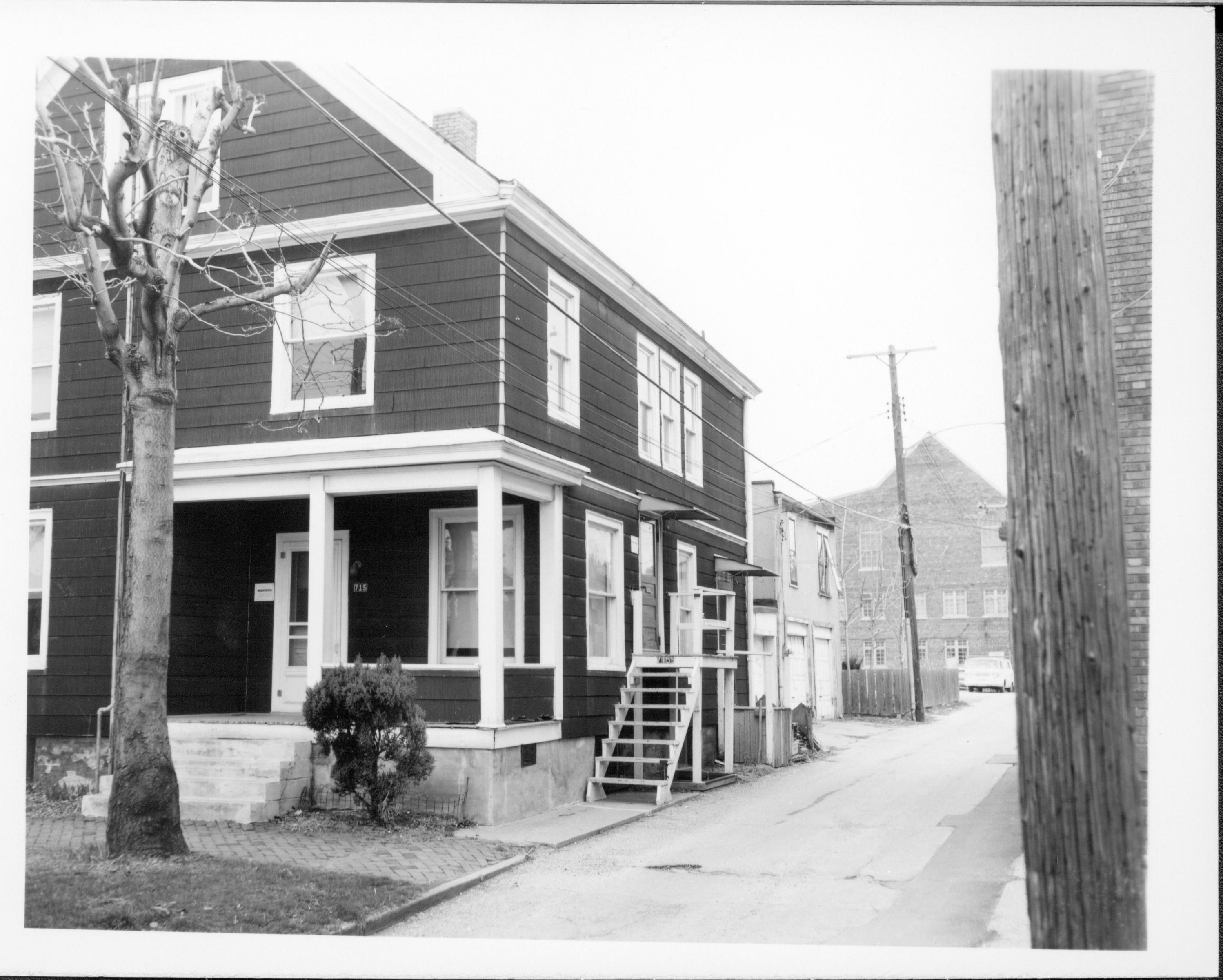 House owned by William Hermes in use as apartments, Block 7, Lot 8 along Jackson Street next to alley.  Two-story garage in center background owned by Eleanor Pruett, Grace Lutheran Church addition in background right. Area is now Visitor Center. Looking North/Northwest from Jackson Street and alley Hermes, Pruett, Grace Lutheran Church, Jackson Street, alley, Visitor Center
