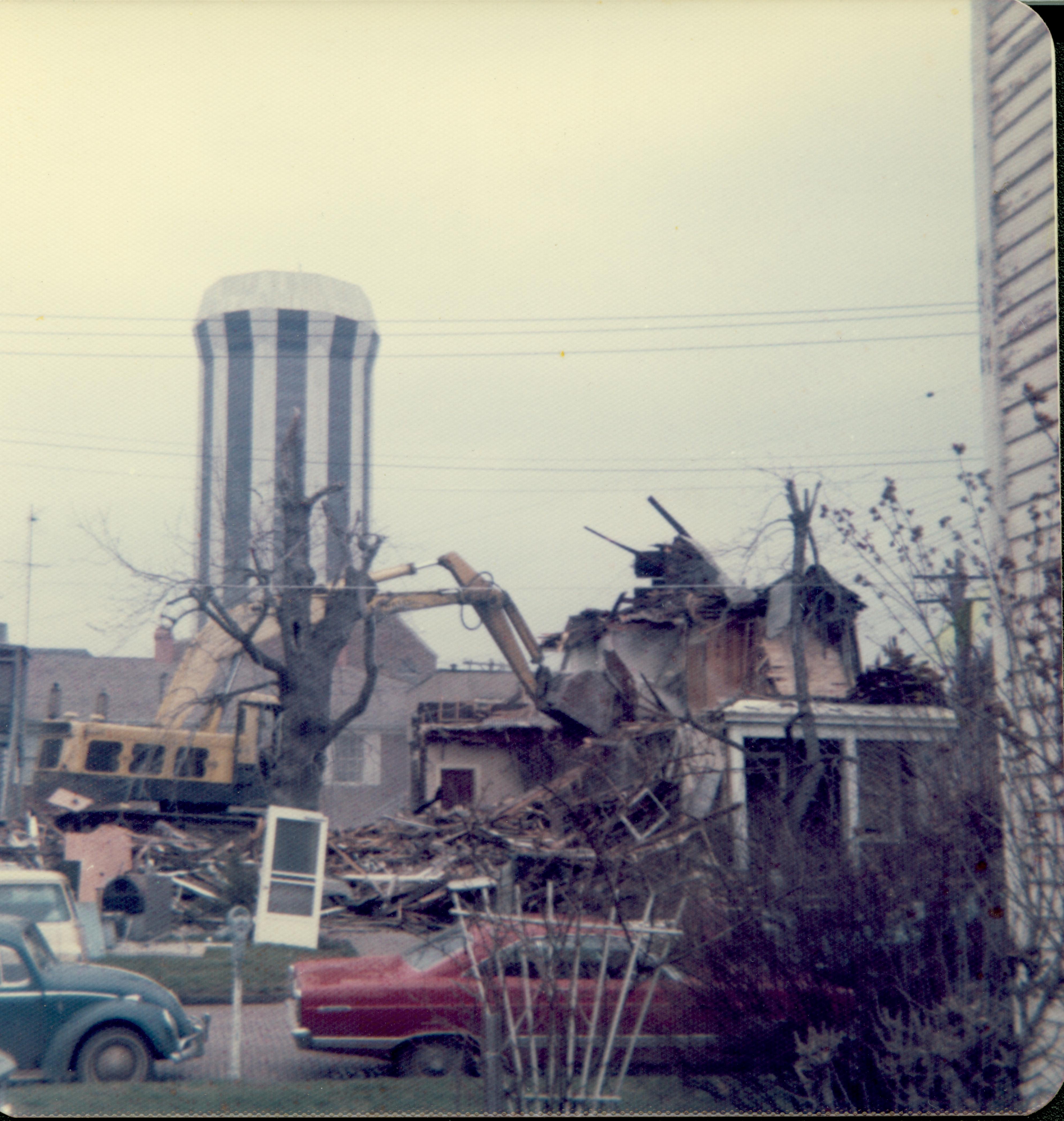 House owned by William Hermes in process of being razed, Block 7, Lot 8 along Jackson Street. Hilton Hotel tower in background center.  House owned by Helen Watkins on far right across the street.  Area is now Visitor Center  Looking North from South of Jackson Street. Hermes, Watkins, Hilton Hotel, Jackson Street, Visitor Center