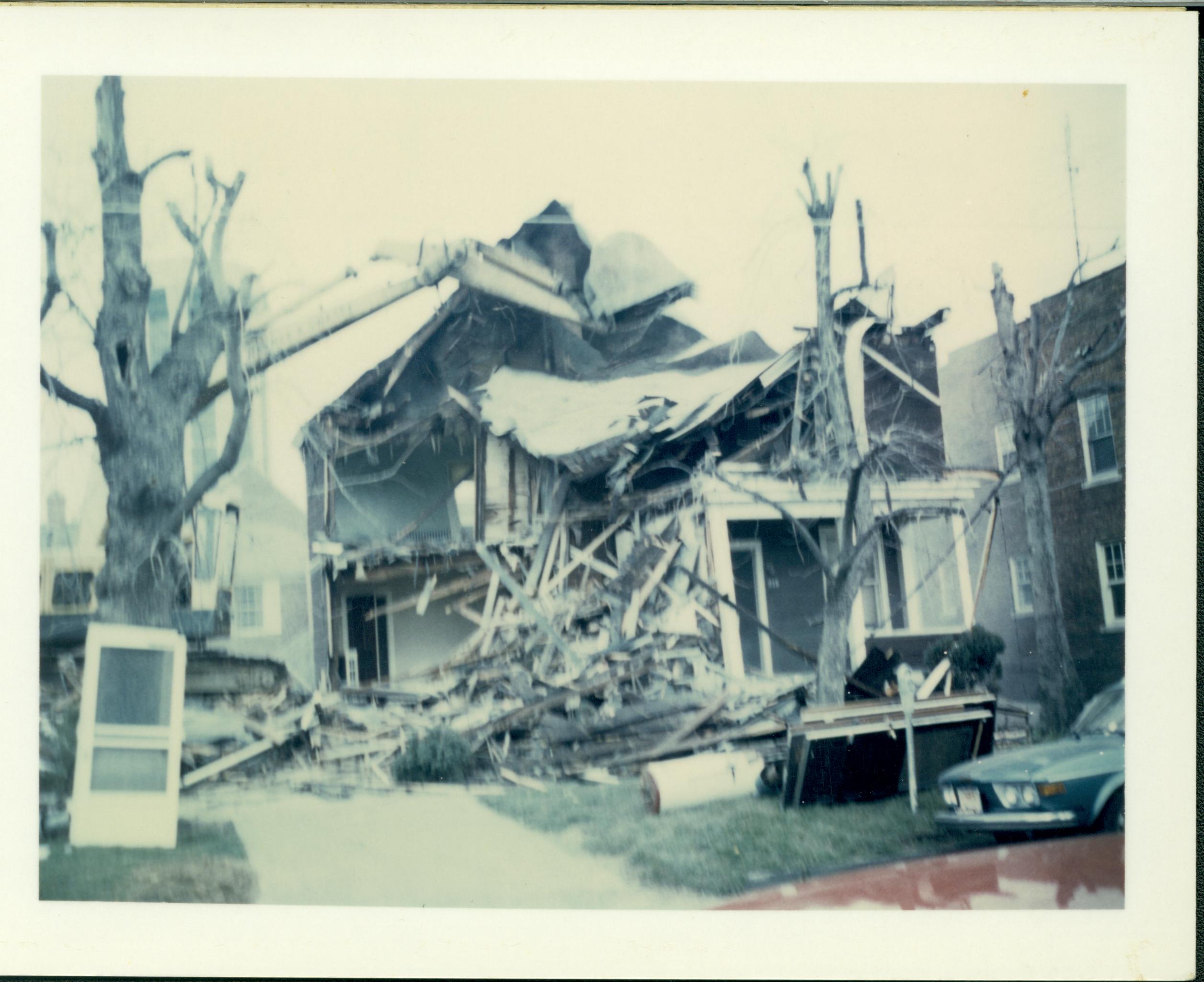 House owned by William Hermes in process of being razed. Brick building on right owned by Herman Hofferkamp.  Hilton Hotel tower semi-visible behind tree on left. Area is now Visitor Center. Looking North from Jackson Street Hermes, Hofferkamp, Hilton Hotel, razing, Visitor Center, Jackson Street