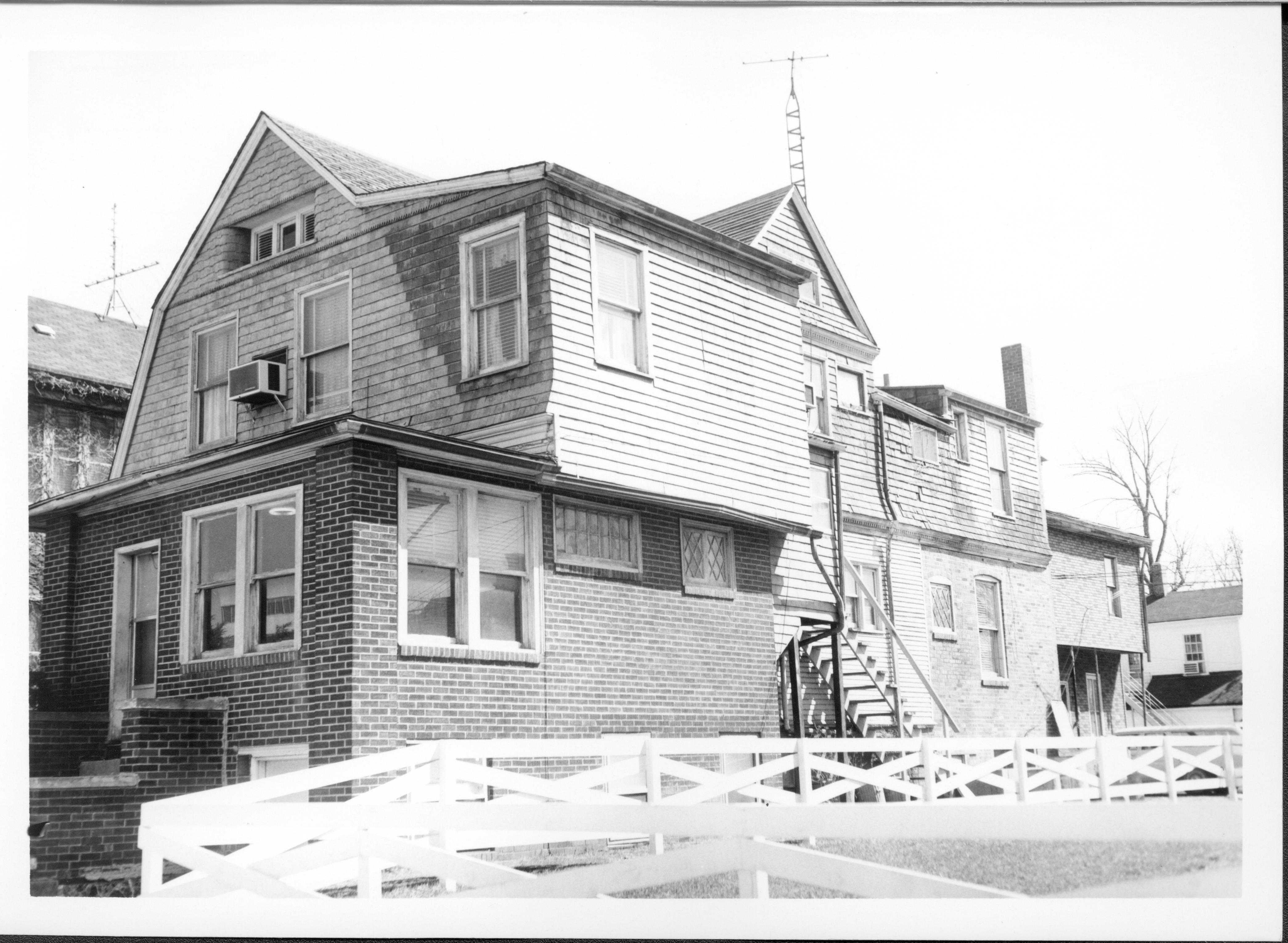 House owned by Bernard W. Bowman in use as apartments, Block 7, Lots 16 & 15 along Capitol Ave. The Beedle house (with overhang) and Dean House (with air conditioner in window) are in background right.  Area is now empty Walters lot  Looking Southeast from Capitol Ave. Bowman, Capitol Ave, Walters lot, Beedle, Dean