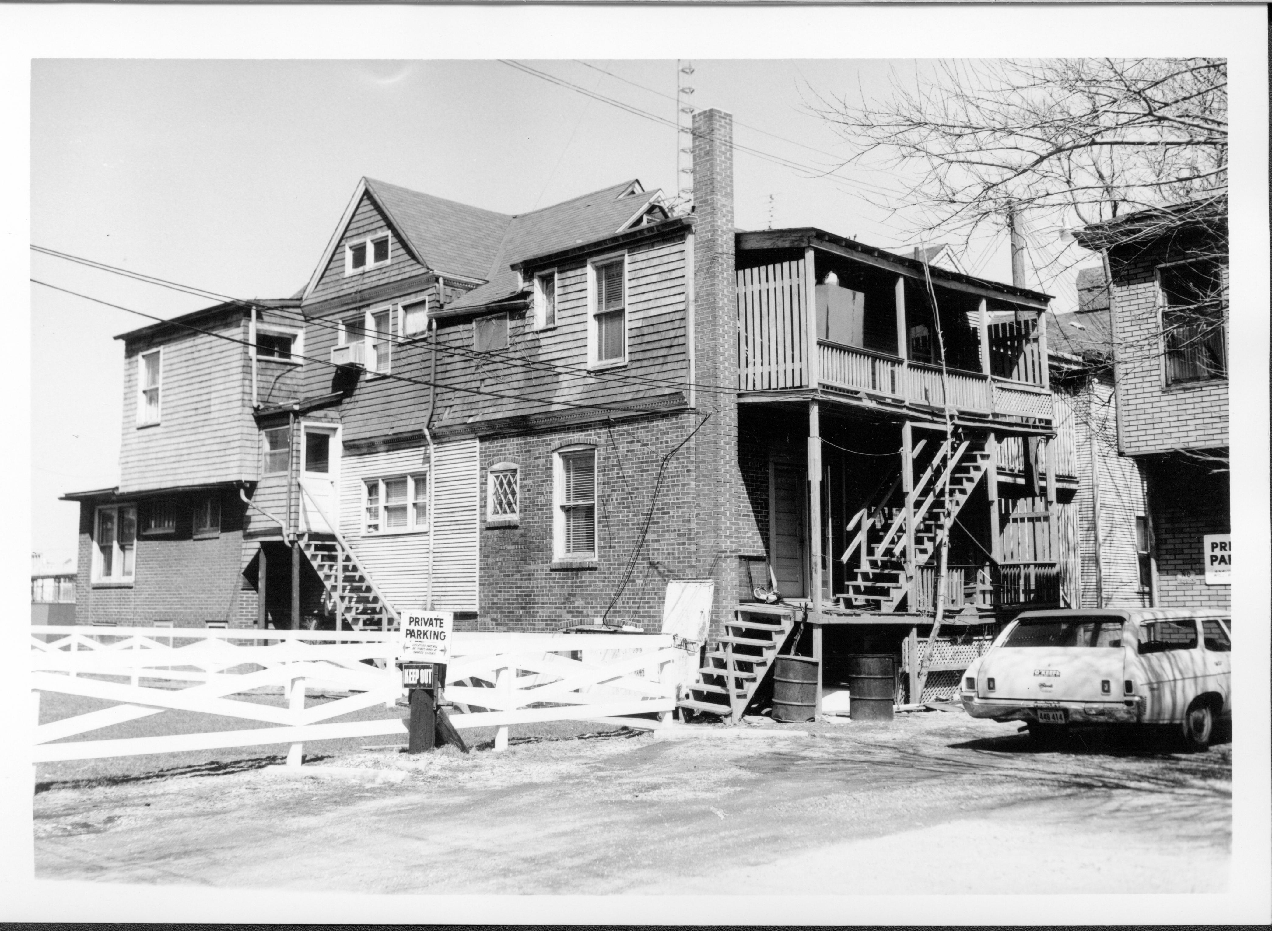House owned by Bernard W. Bowman in use as apartments, Block 7, Lots 16 & 17 facing Capitol Ave. Beedle house is at far right in front of station wagon.  Area is now empty Walters lot. Looking Northeast from alley Bowman, Beedle, Capitol Ave., Walters lot