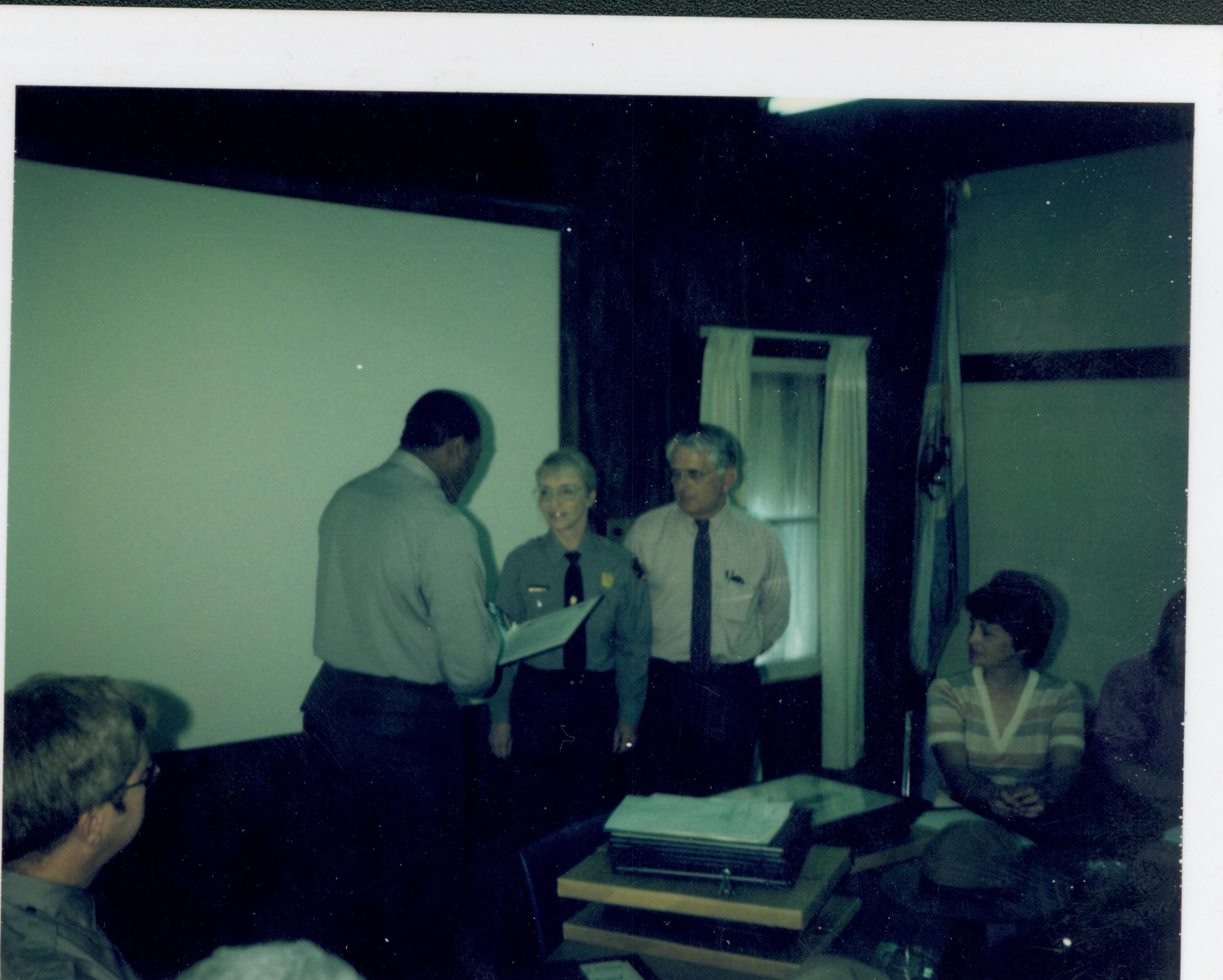 Awards ceremony for staff in Conference Center.  Supt. Gentry Davis gives award to Education Coord. Judy Winkelmann and her husband and volunteer, Joe looking Northwest on second floor awards, staff, Conference Center, volunteer