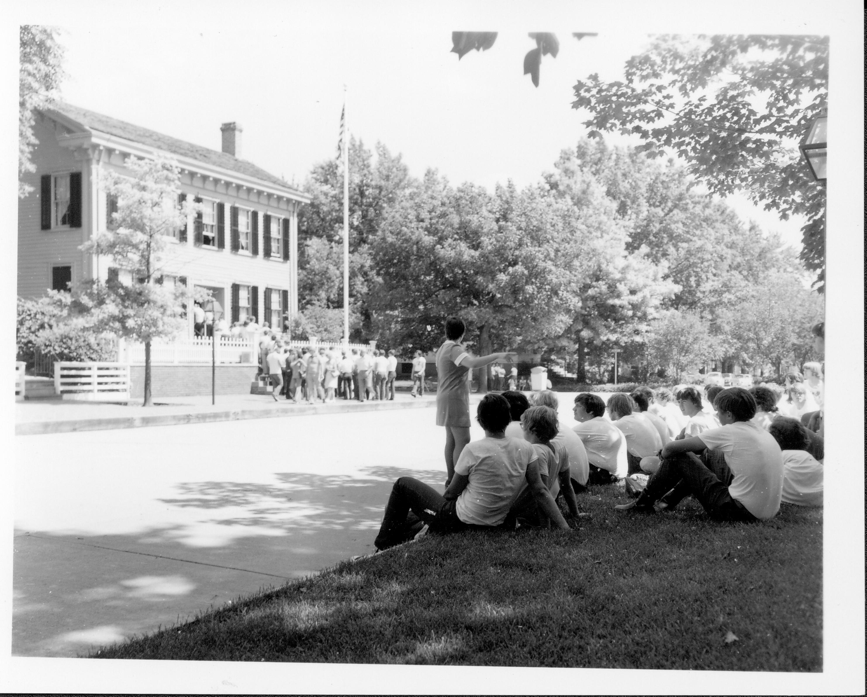 Seasonal Interpreter Jacque Williams and group across from Lincoln Home Class 8, Pic. 5 Interpretive Staff, 1973