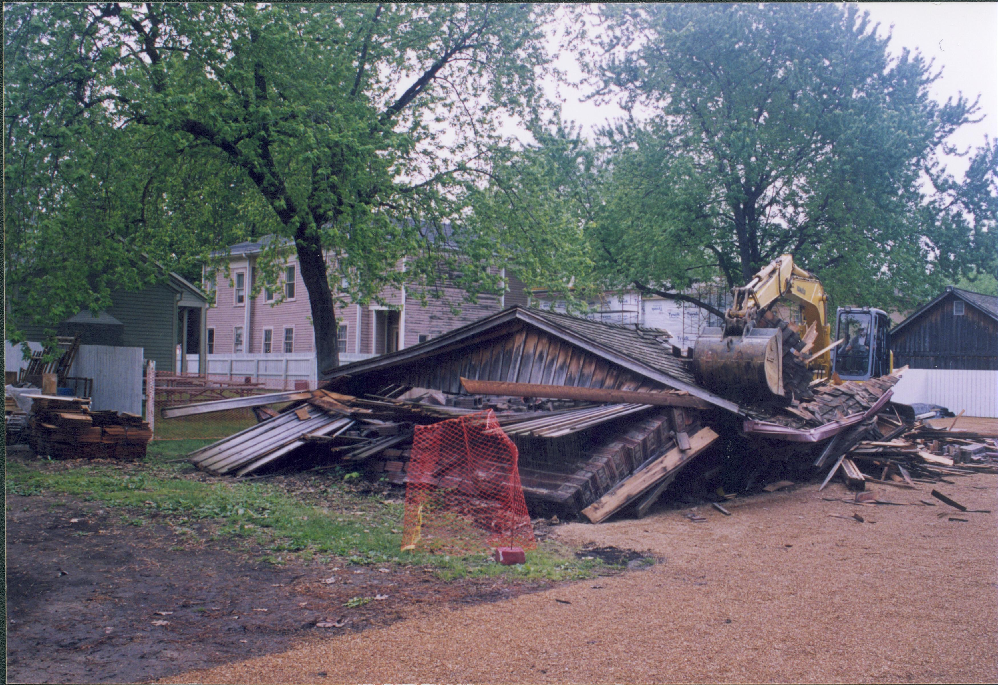Maintenance Shed removal - Sprigg shed tear down on non-historic barn. Maintenance Work Leader Vee Pollock operates crane. Sprigg House on far left, Miller House in background left. Maintenance shed in background right. Alley between 7th and 8th Street in foreground Looking Southeast from Jackson Street and alley intersection Sprigg, shed, demolition, Miller, alley, staff