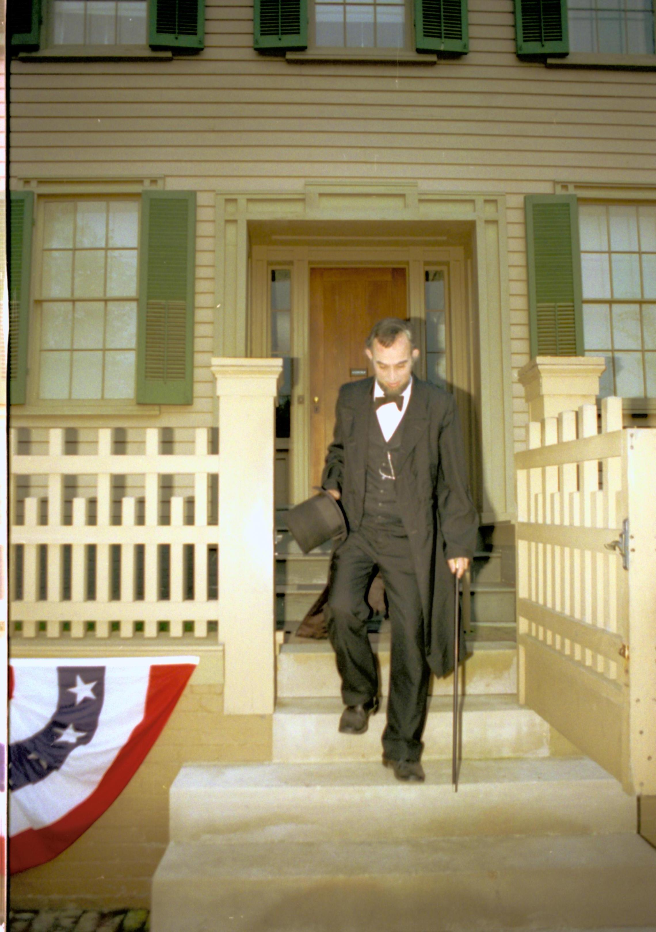 Lincoln impersonator decending front steps of home. Lincoln Home NHS- Coast Guard Band Concert concert, Coast Guard