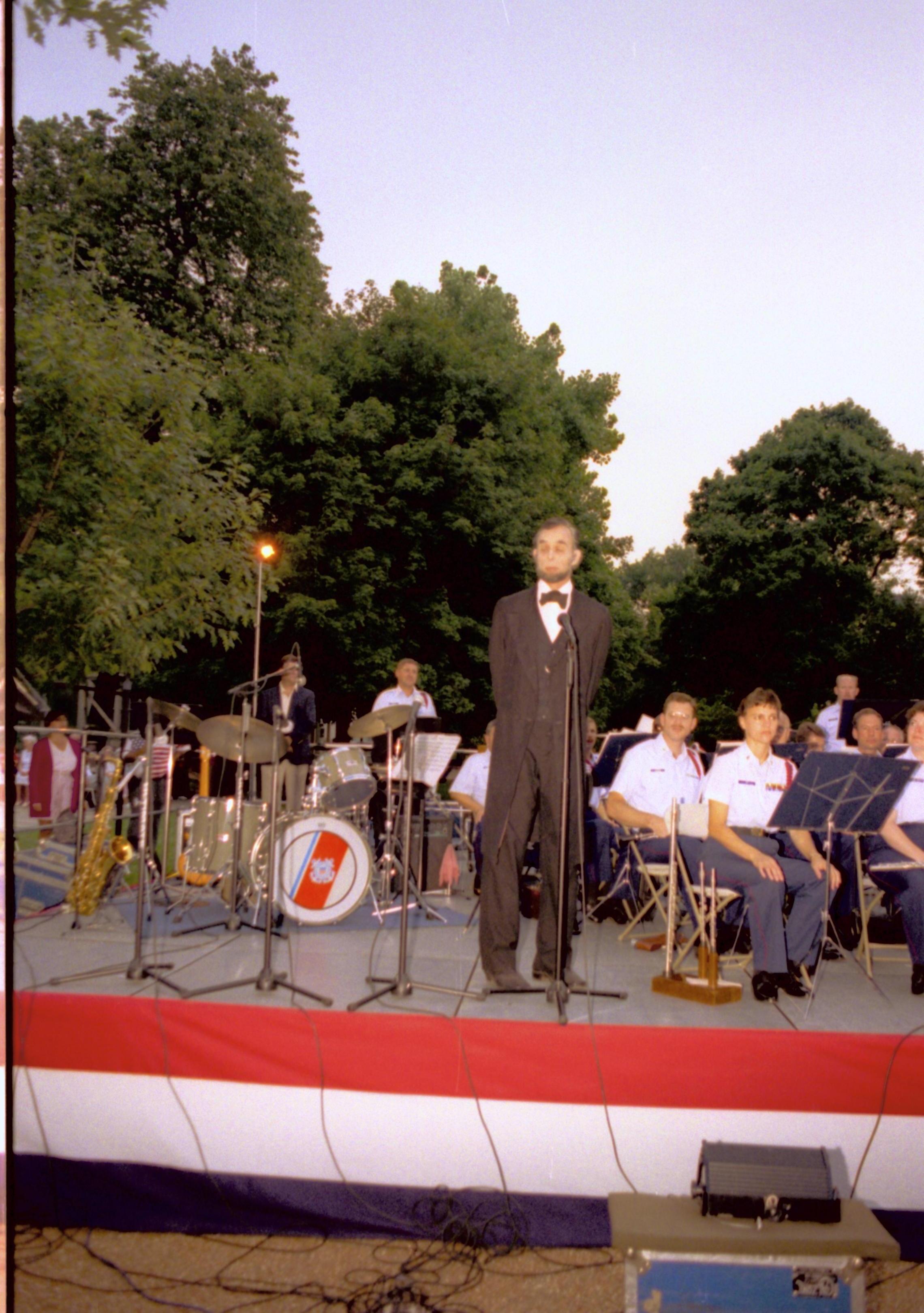 Lincoln impersonator standing on state speaking. Lincoln Home NHS- Coast Guard Band Concert concert, Coast Guard