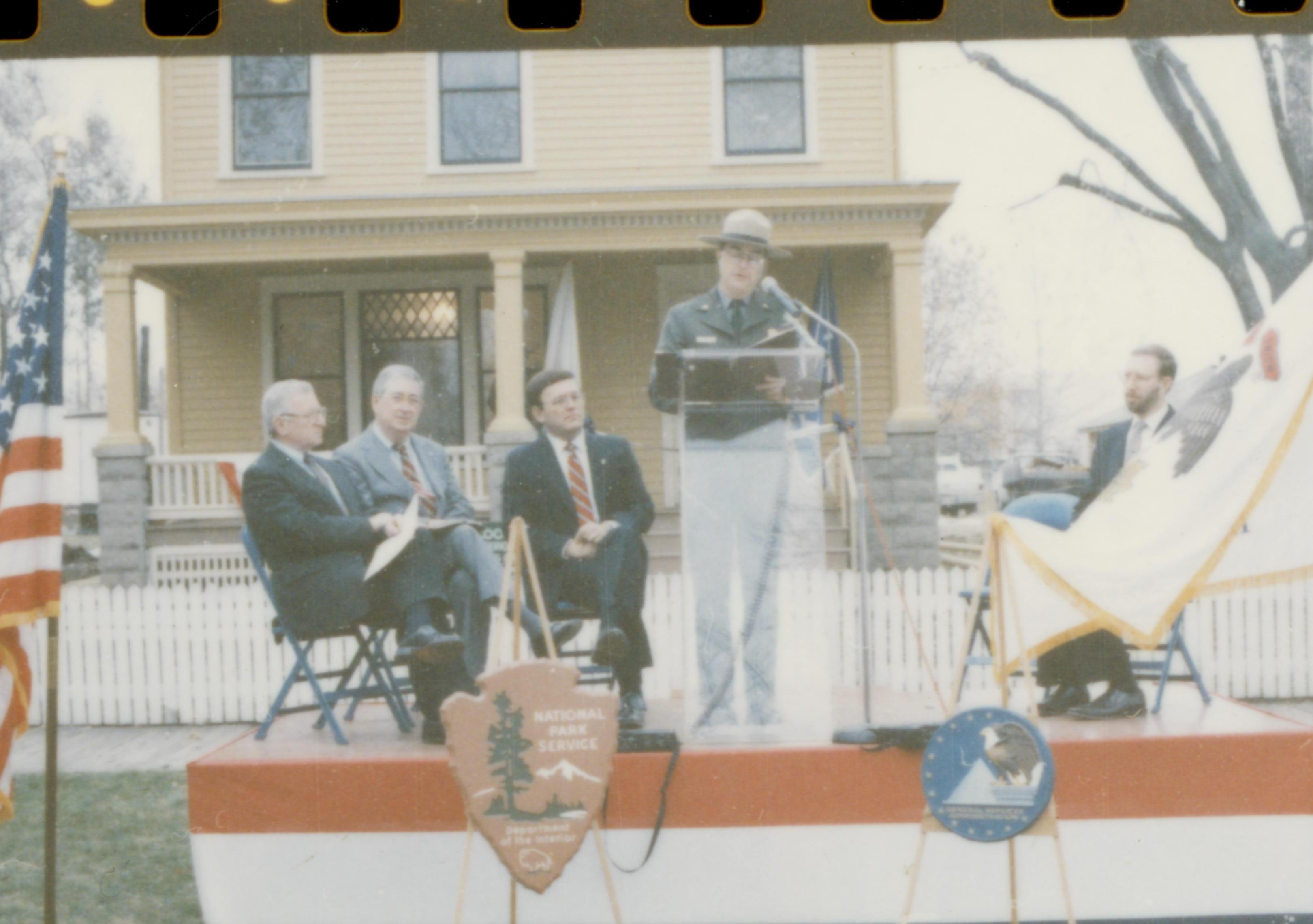 Five men on speakers platform in front of Cook house Lincoln Home NHS- Cook House Re-opening, 1 Cook, ceremony