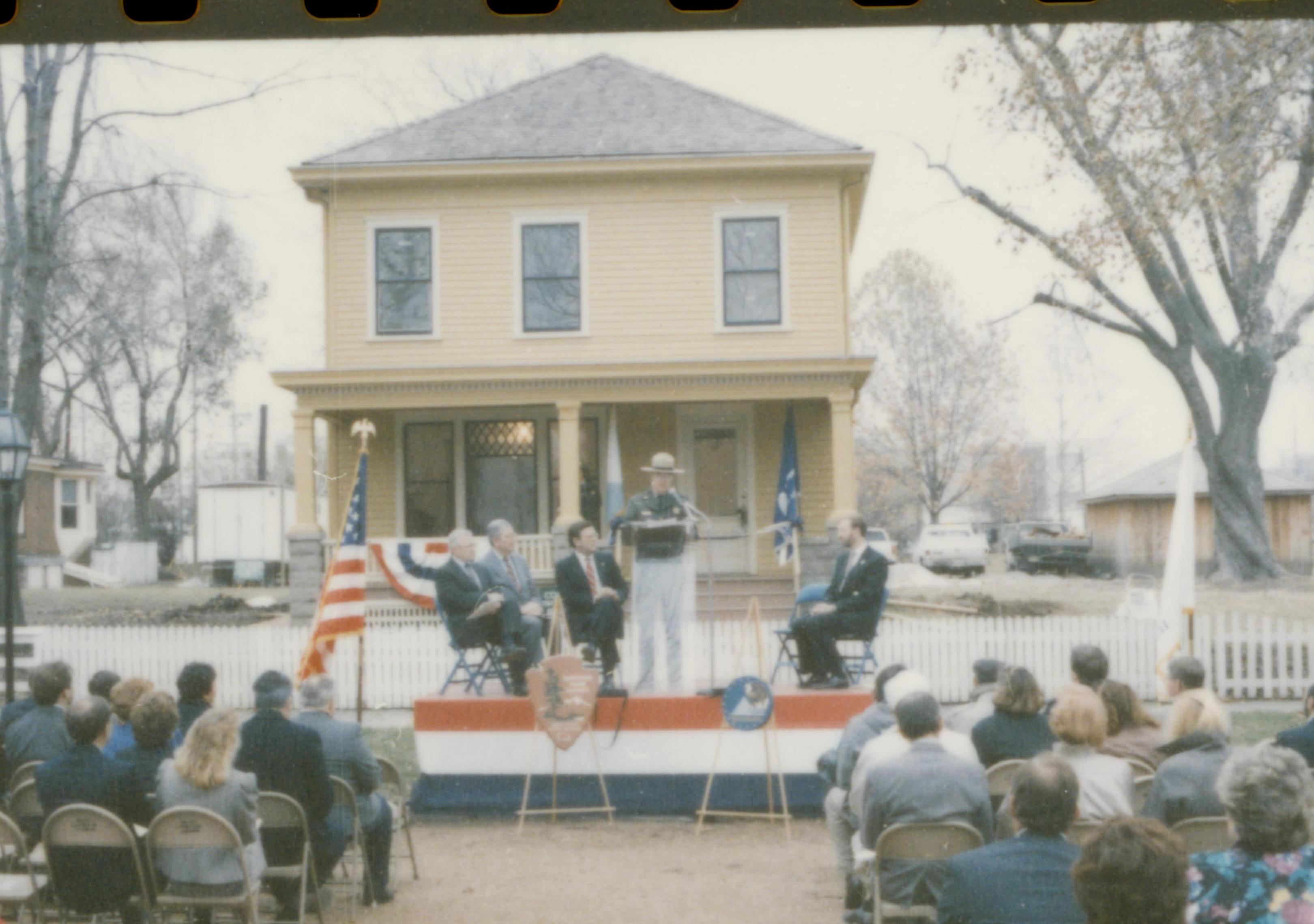 Five men on speakers platform in front of Cook house Lincoln Home NHS- Cook House Re-opening, 1 Cook, ceremony