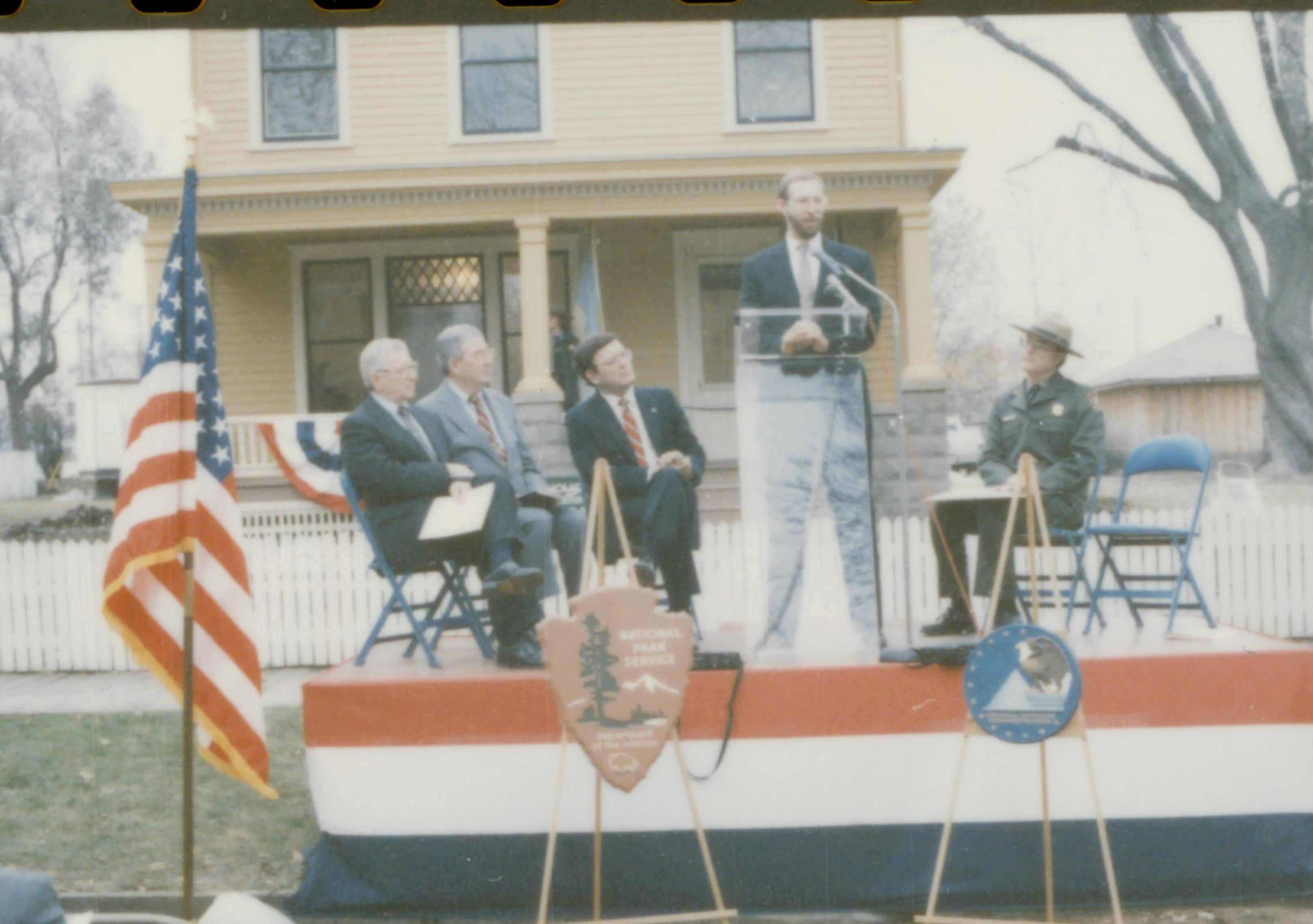 Five men on speakers platform in front of Cook house Lincoln Home NHS- Cook House Re-opening, 1 Cook, ceremony