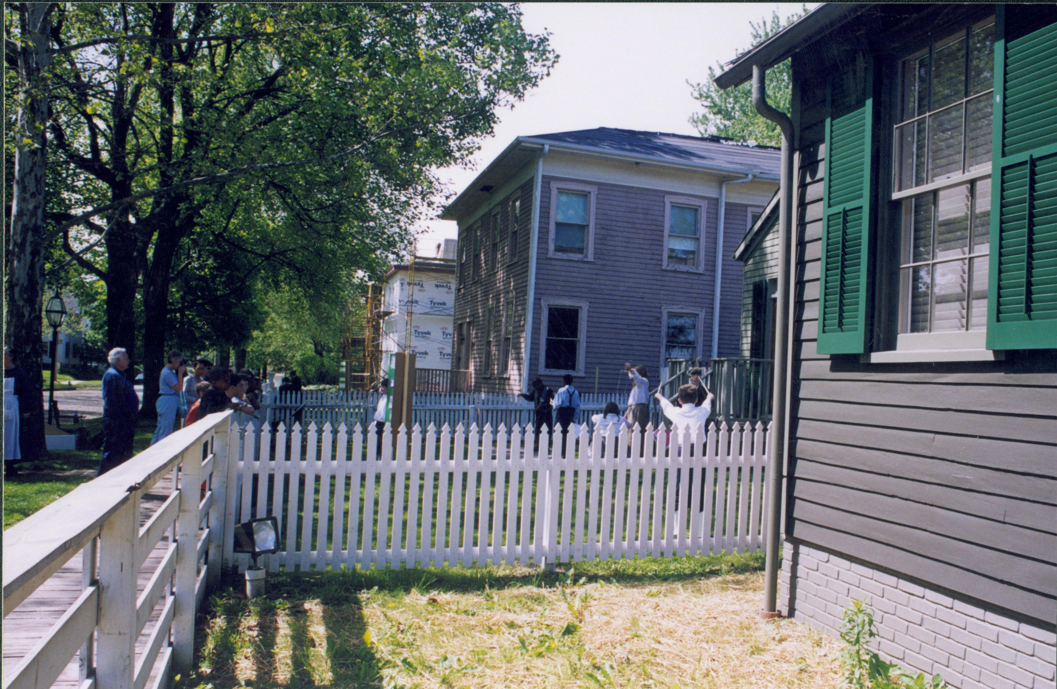 Dubois School Living History program - students demonstrate 19th century games and toys in the Sprigg House front yard. School groups and parents watch. Under-restoration Dubois House in far background center. Miller House in background center. Sprigg and Corneau houses on right. Looking South from Corneau front yard Dubois School, living history, Dubois, Miller, Sprigg, Corneau, students, school groups