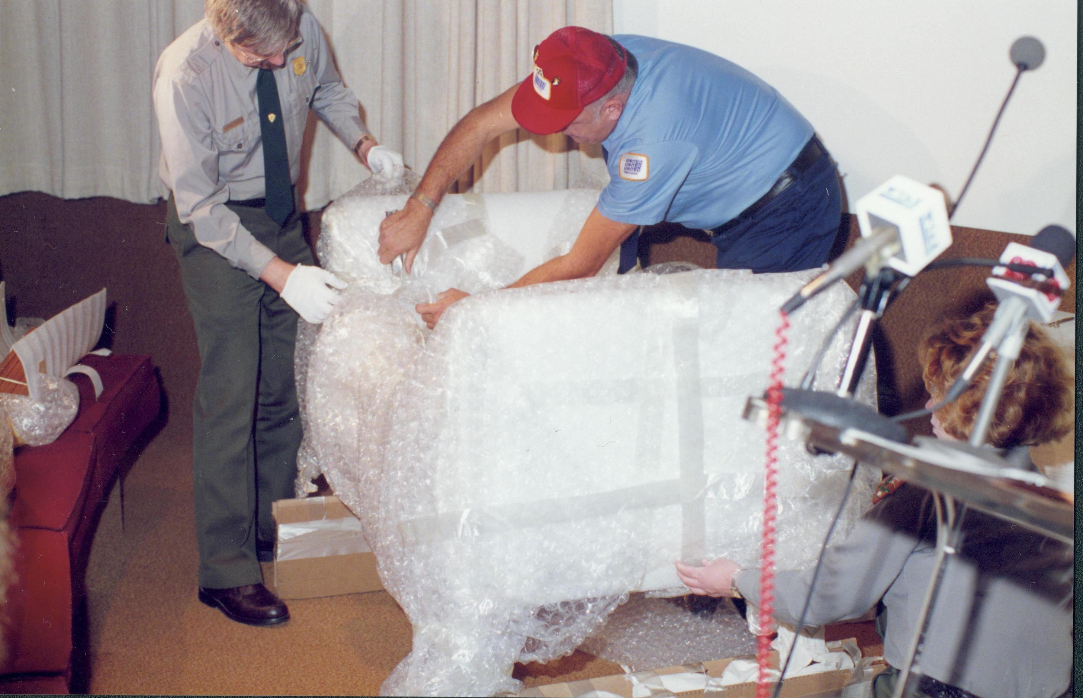 Two men unwrapping furniture. Lincoln Home NHS- Bring Furniture Back Home furniture, conference, cradle