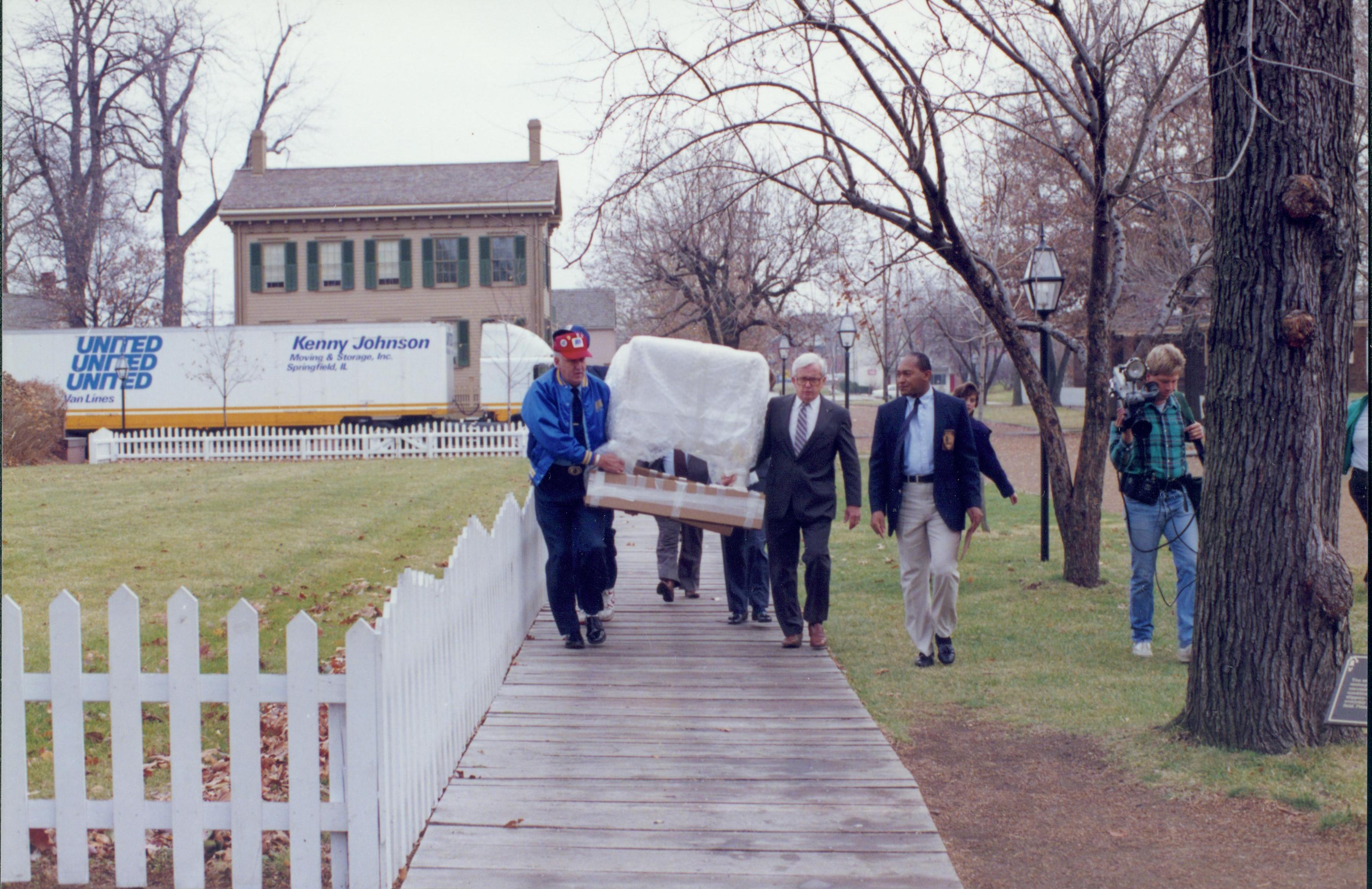 Men carrying wrapped furniture down board walk. Lincoln Home NHS- Bring Furniture Back Home furniture, conference, cradle