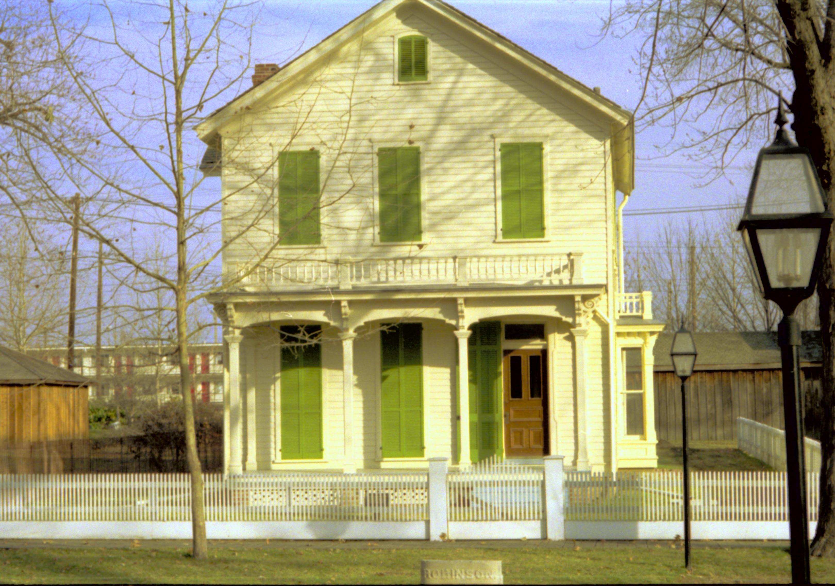 Front view of yellow house with green shutters. Lincoln Home NHS- Bring Furniture Back Home, 79A Robinson