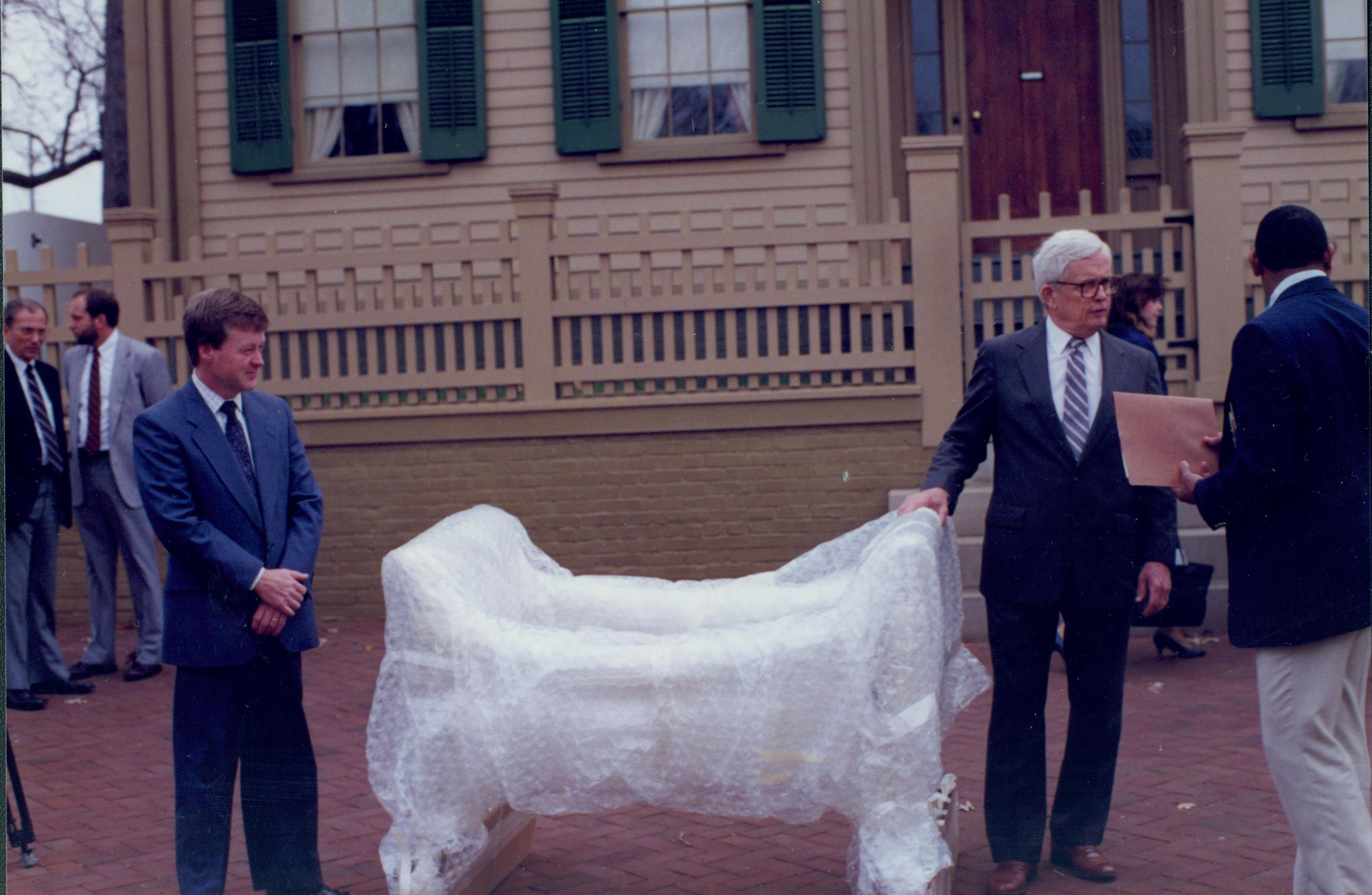 Two men standing by wrapped up furnitire. Lincoln Home NHS- Bring Furniture Back Home furniture, bed