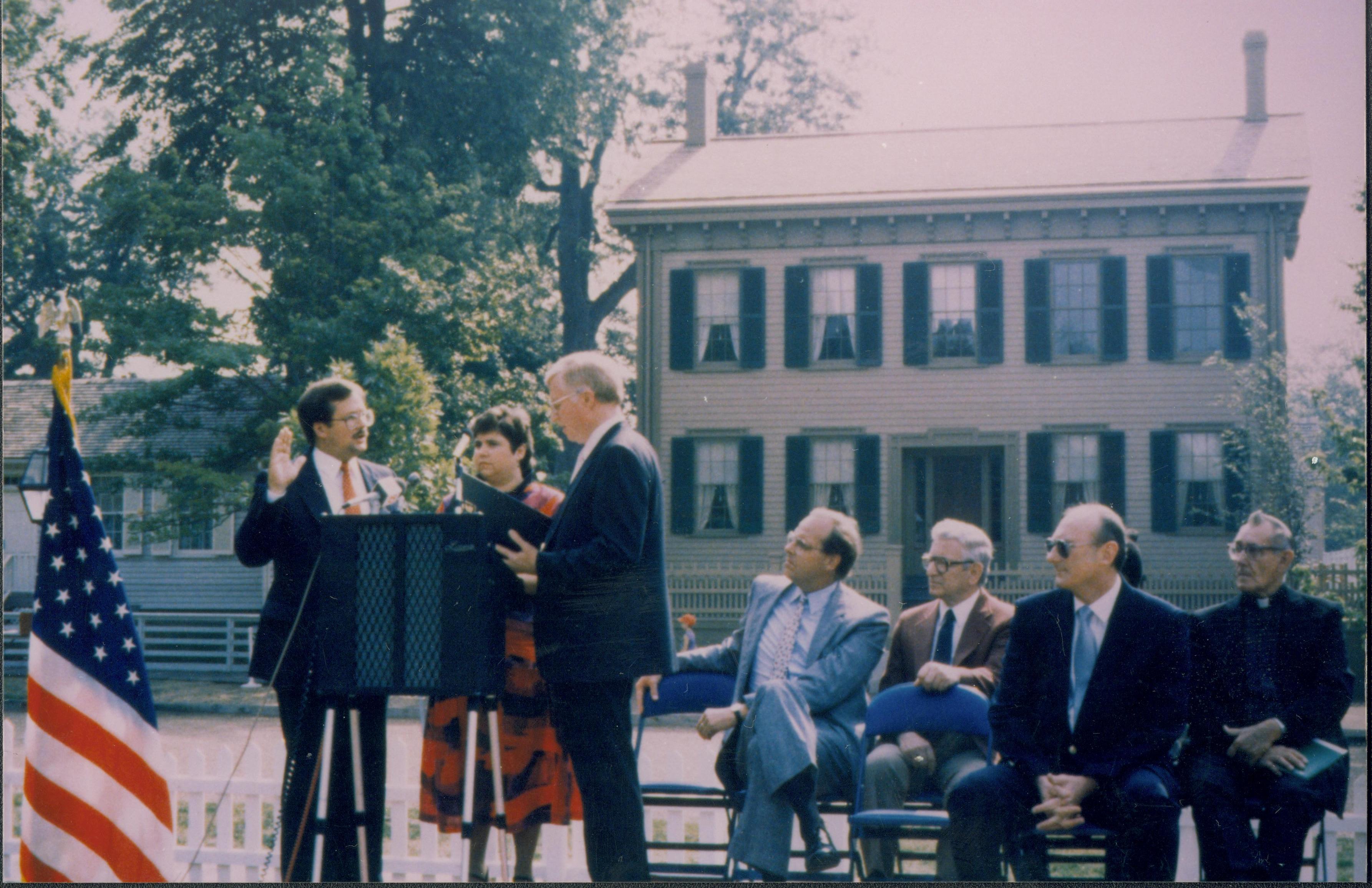 Man being sworn in on platform. Lincoln Home NHS- Bring Furniture Back Home ceremony, oath