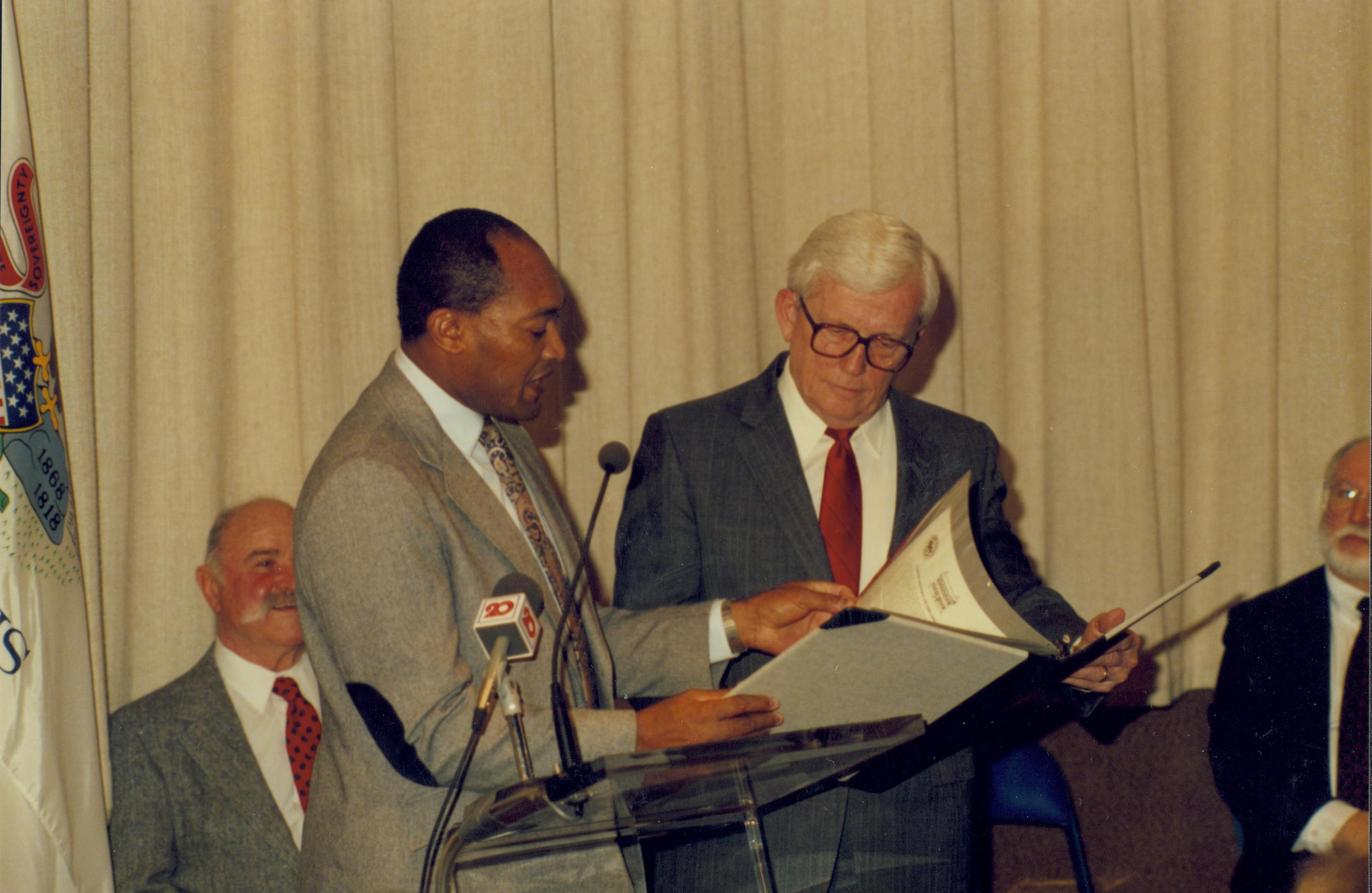 Two men standing at podium looking at a folder. Lincoln Home NHS- Paul Findley Recognition Award, 4314 Finley, award