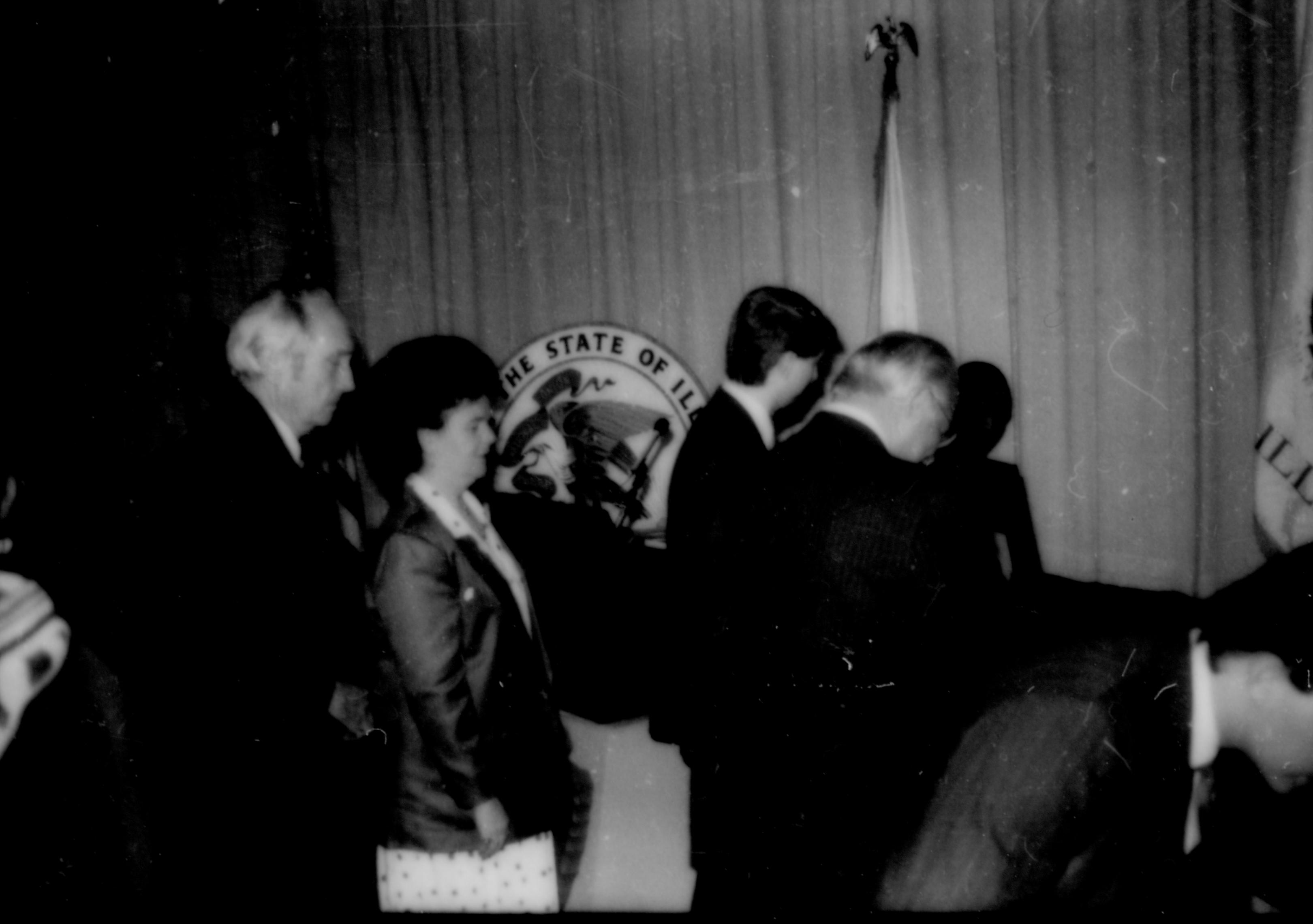 People standing i  front of state seal and curtain. Lincoln Home NHS- Paul Findley and Michel VIP visit, 129 Finley, Michel, visit, reception