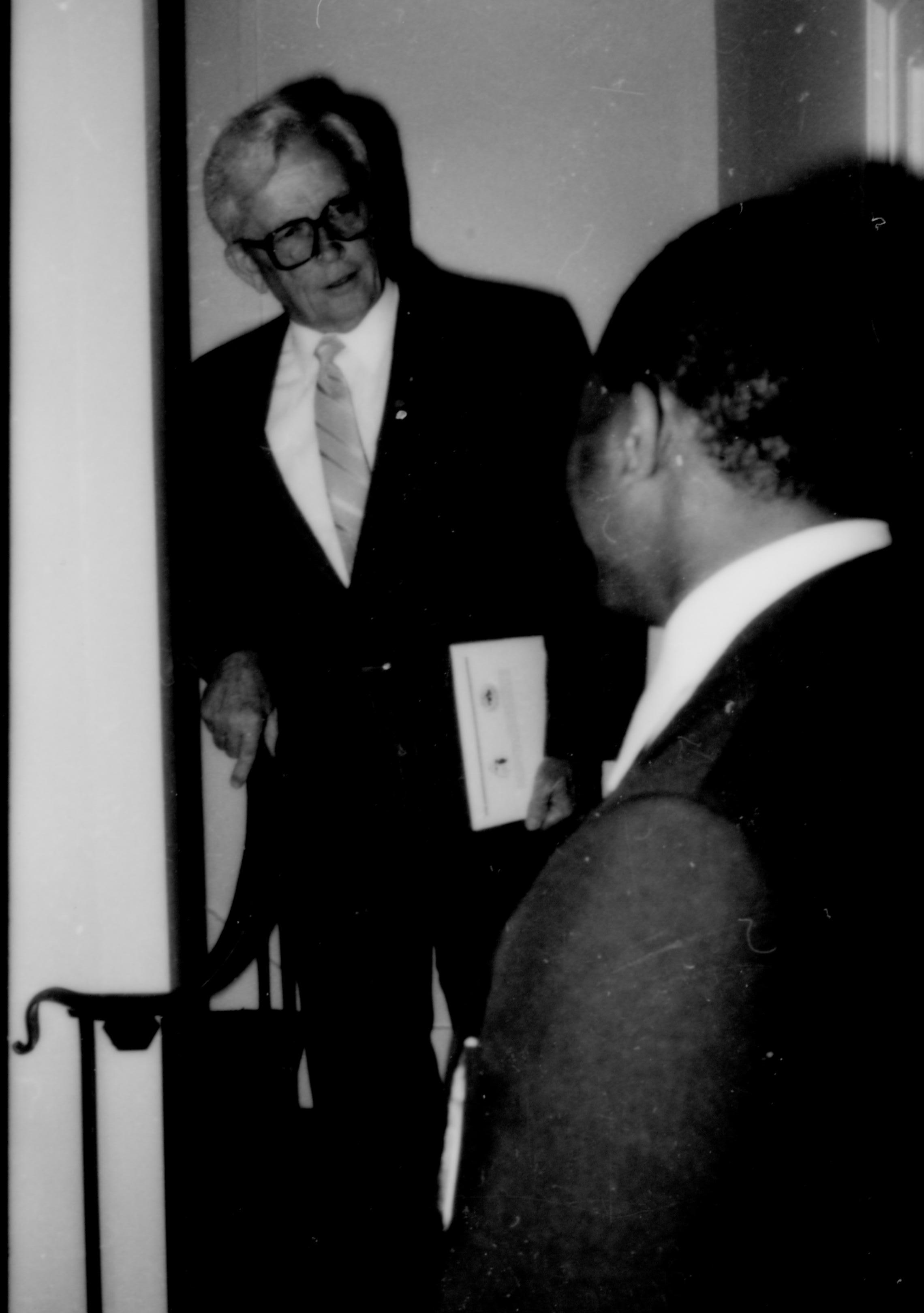 Two men standing behind railing conversing. Lincoln Home NHS- Paul Findley and Michel VIP visit, 129 Finley, Michel, visit, reception