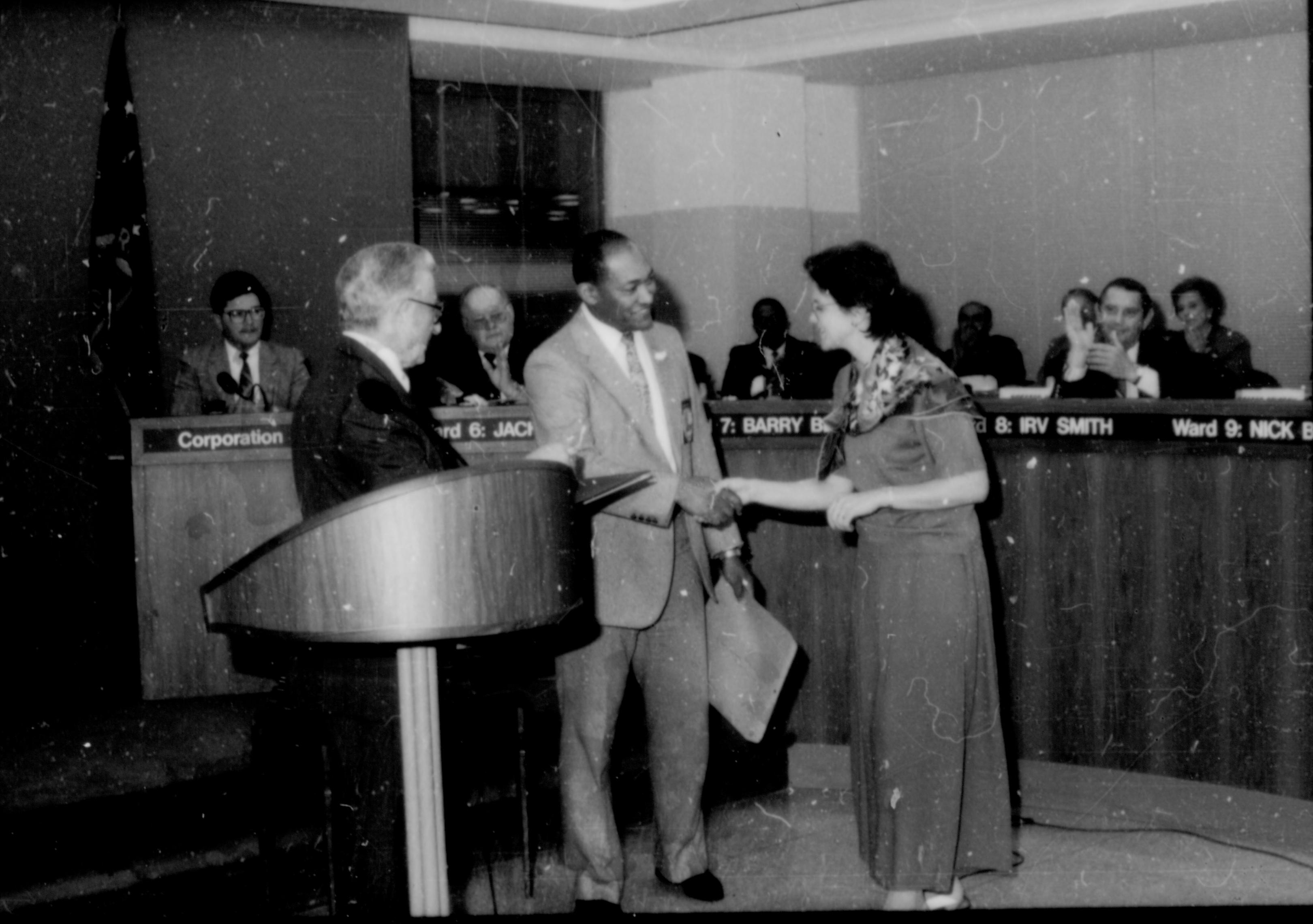 Man congratulating lady in front of City Council. Lincoln Home NHS- City Council Ollie Christmas Award, 133 Award, program