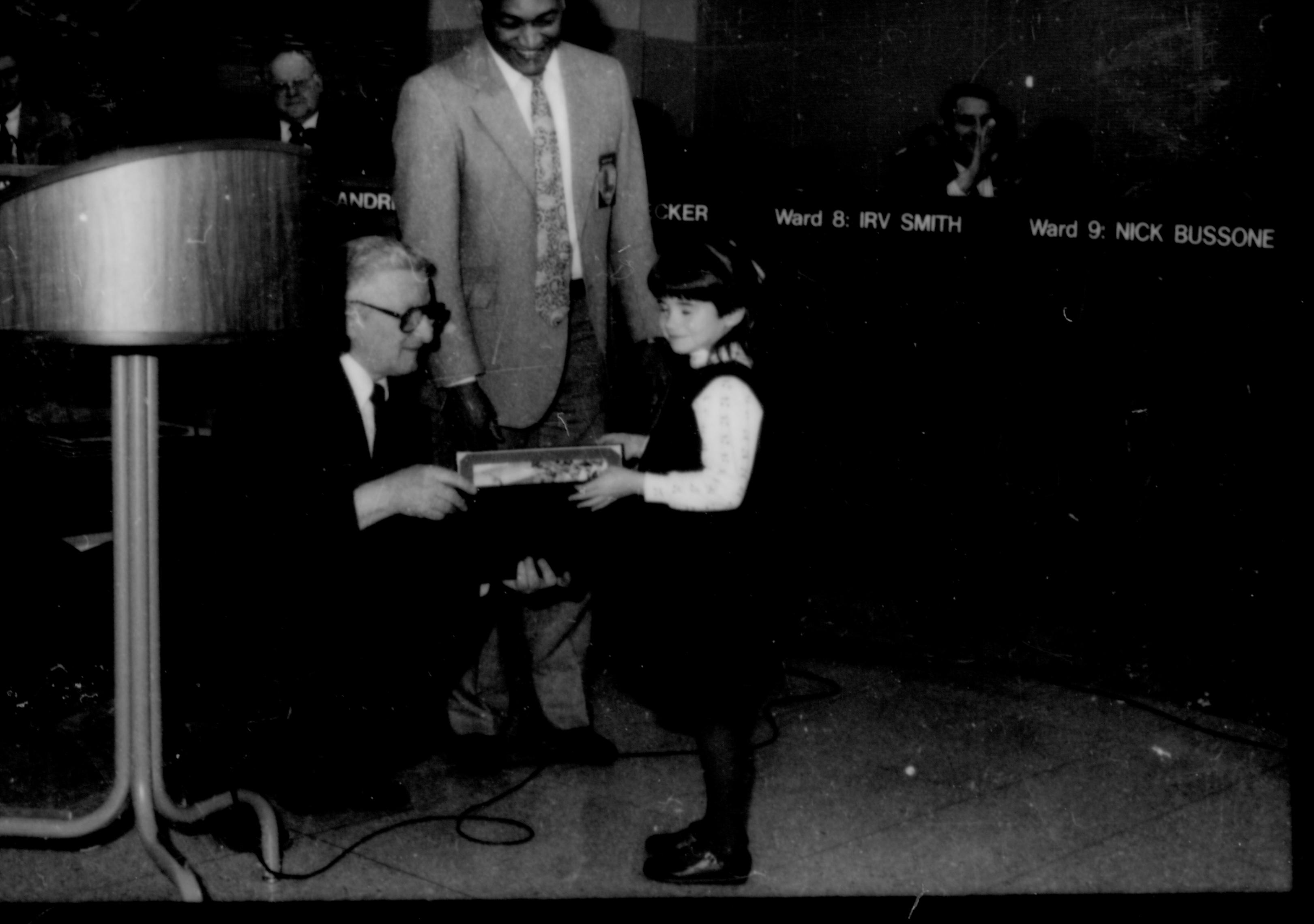 Two men giving award to a little girl. Lincoln Home NHS- City Council Ollie Christmas Award, 133 Award, program