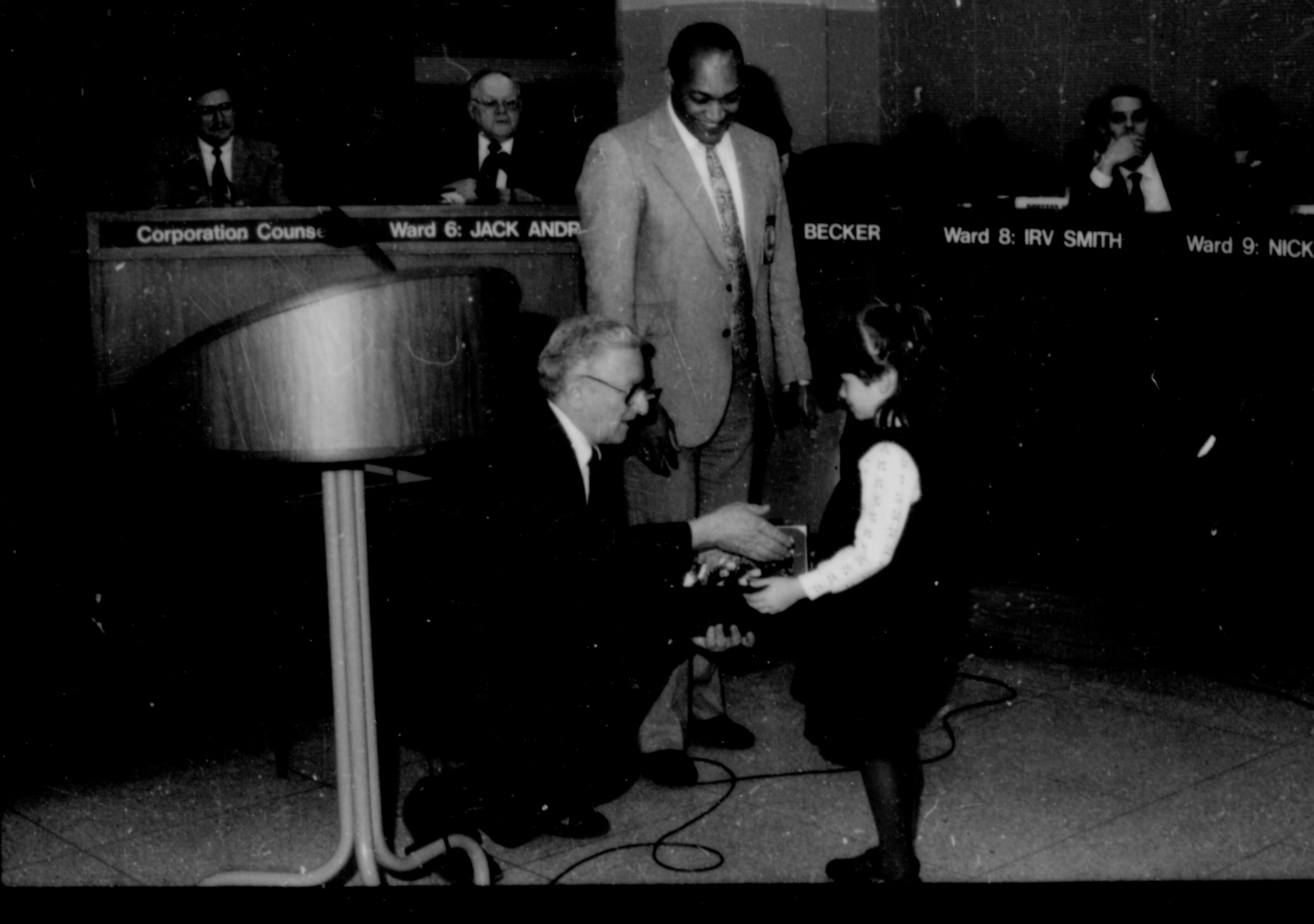 Two men giving award to a little girl. Lincoln Home NHS- City Council Ollie Christmas Award, 133 Award, program