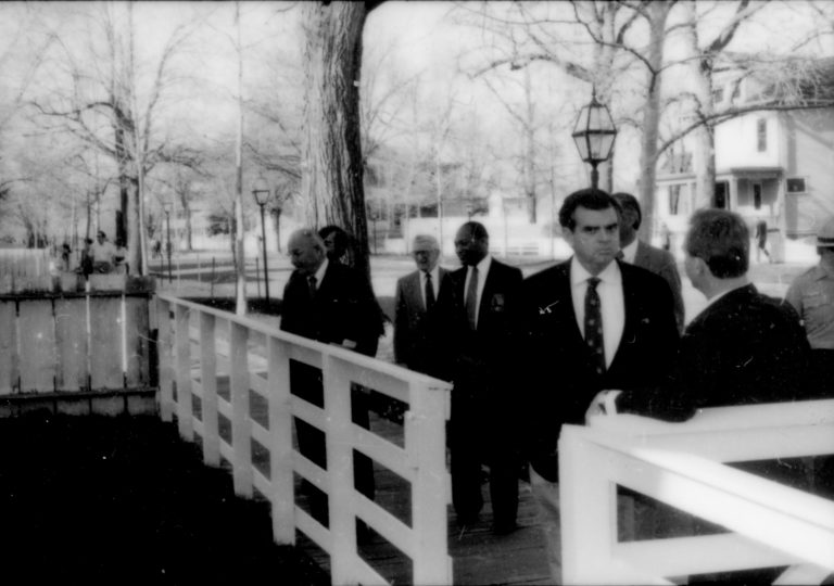 Group of men standing behind white fence. Lincoln Home NHS- Paul Findley and Michel VIP visit, 115 Finley, Michel, tour, visit