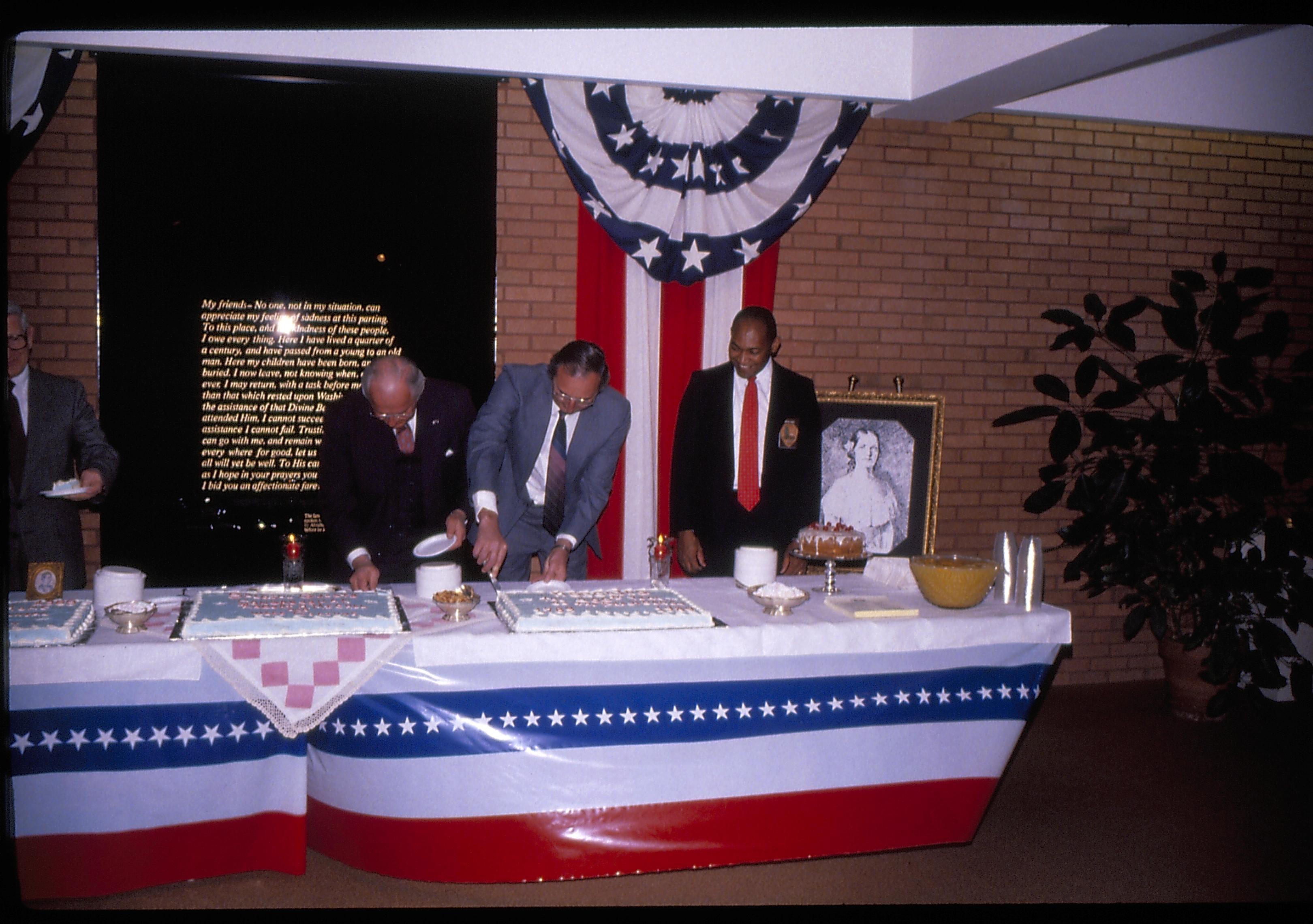 Two men cutting cake behind refreshment table. Lincoln Home NHS- VIP Findley and Michel Visit award, visit, reception