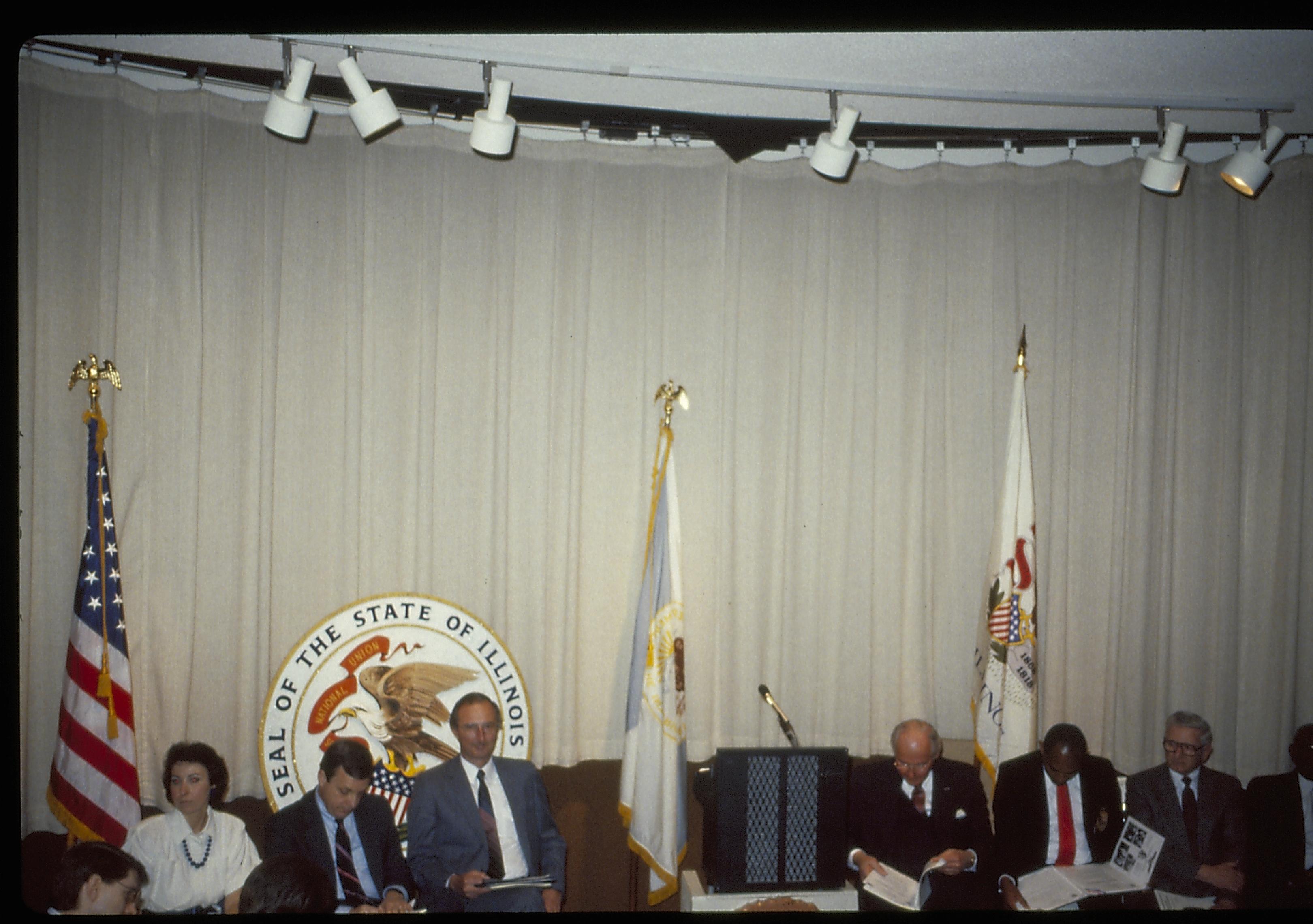 Dignateries seated in VC theater in front of flags and curtin. Lincoln Home NHS- VIP Findley and Michels Visit award, visit, reception