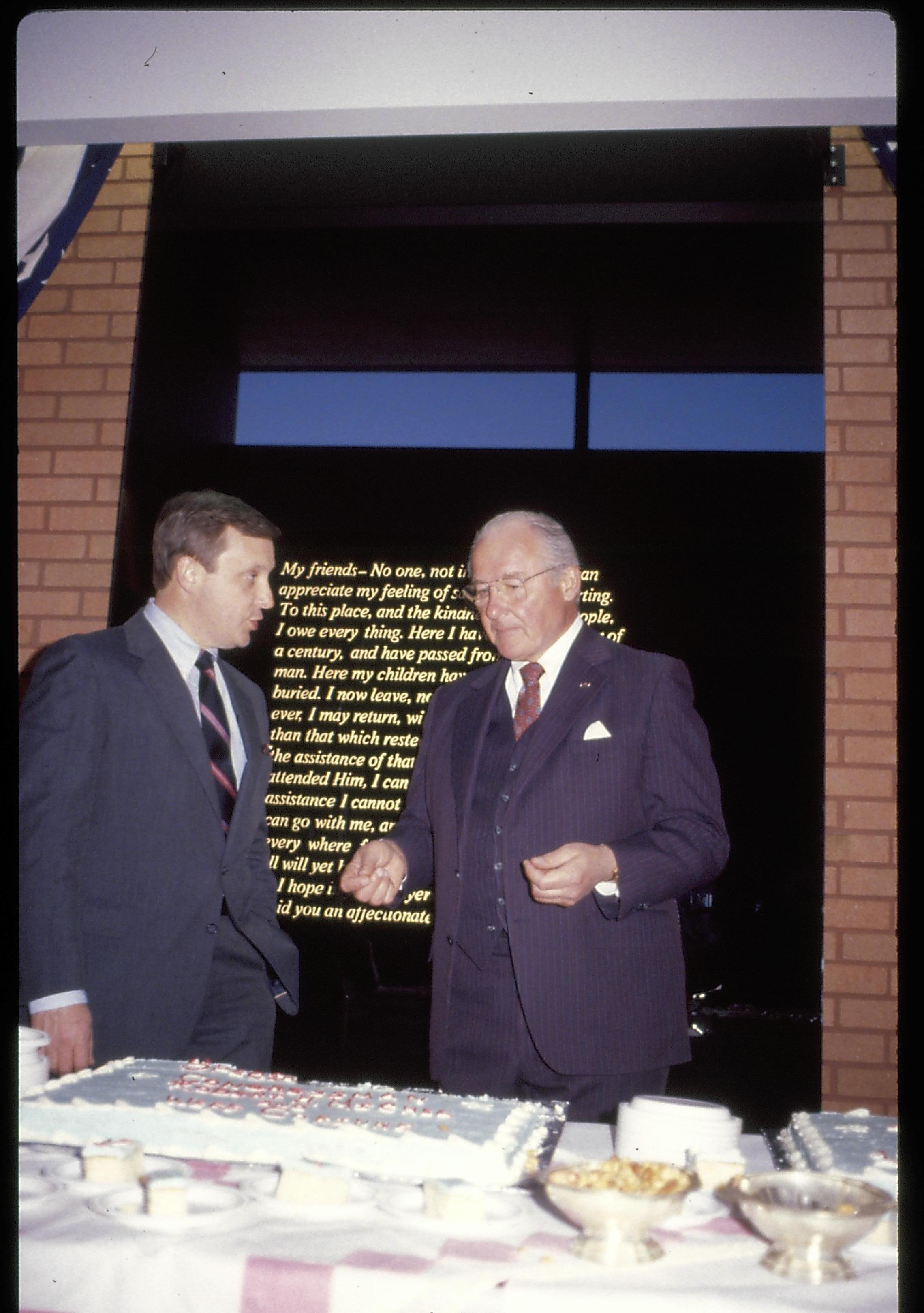 Two men talking standing in front of farewell address sign. Lincoln Home NHS- VIP Findley and Michel Visit award, visit, reception