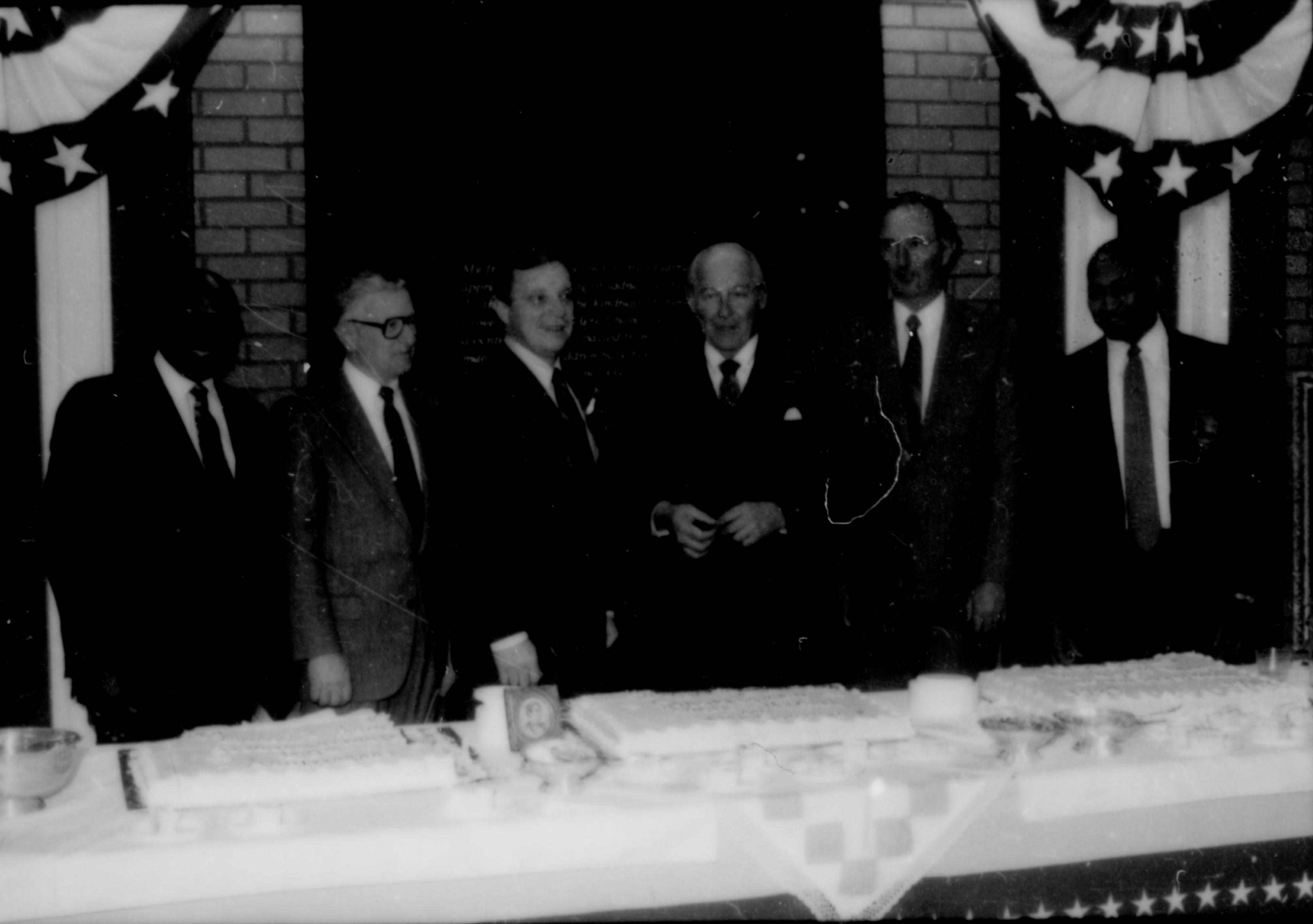 Six men lined up behind table. Lincoln Home NHS- Paul Findley and Michel VIP visit, 119 Finley, Michel, visit, reception