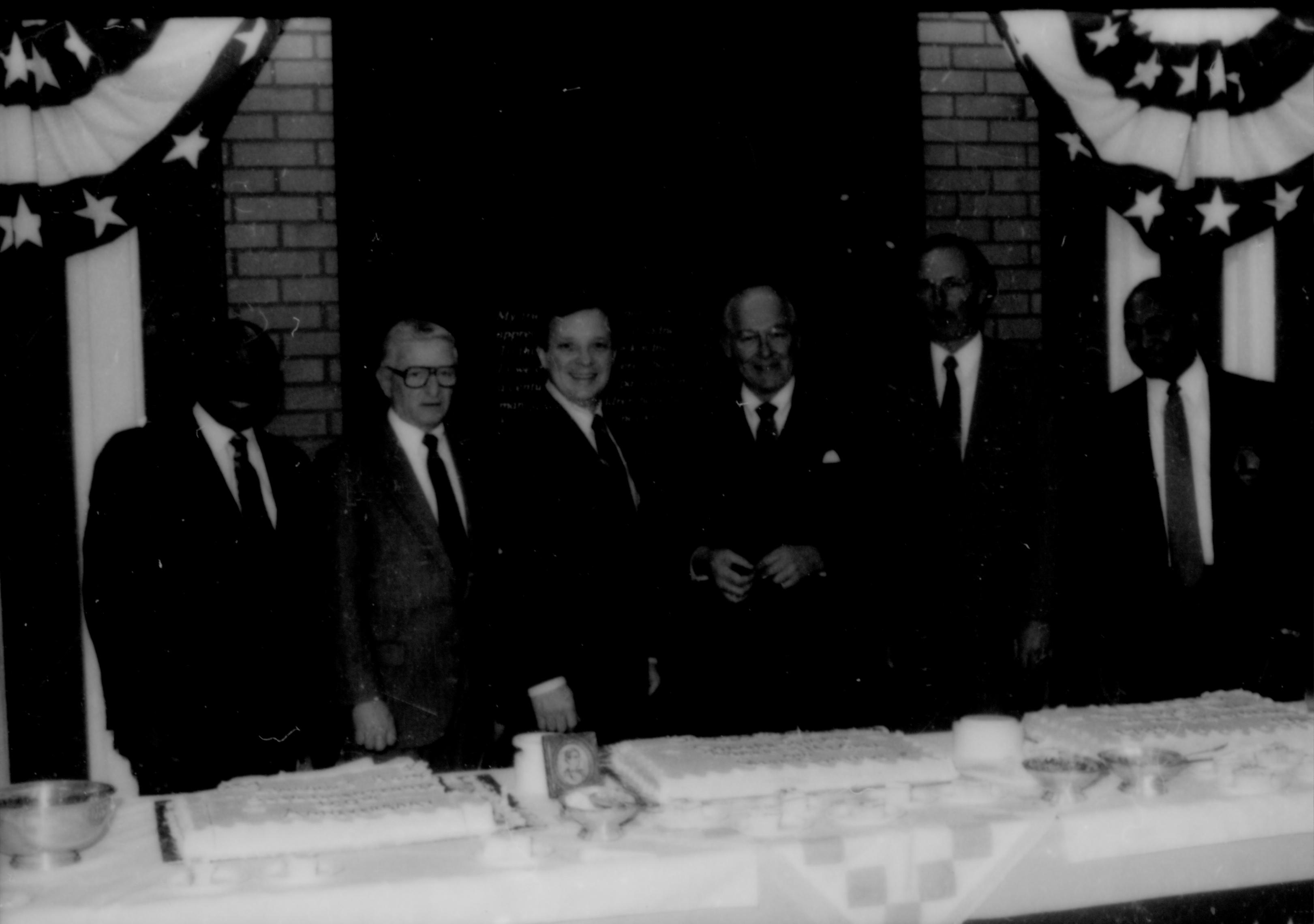 Six men lined up behind table. Lincoln Home NHS- Paul Findley and Michel VIP visit, 119 Finley, Michel, visit, reception