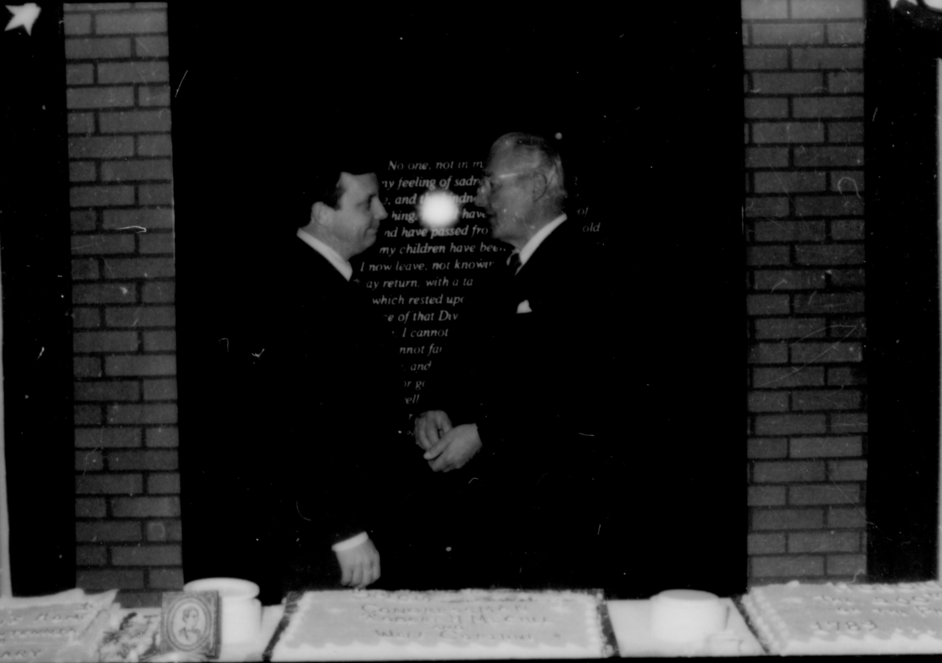 Two men conversing behind table. Lincoln Home NHS- Paul Findley and Michel VIP visit, 119 Finley, Michel, visit, reception