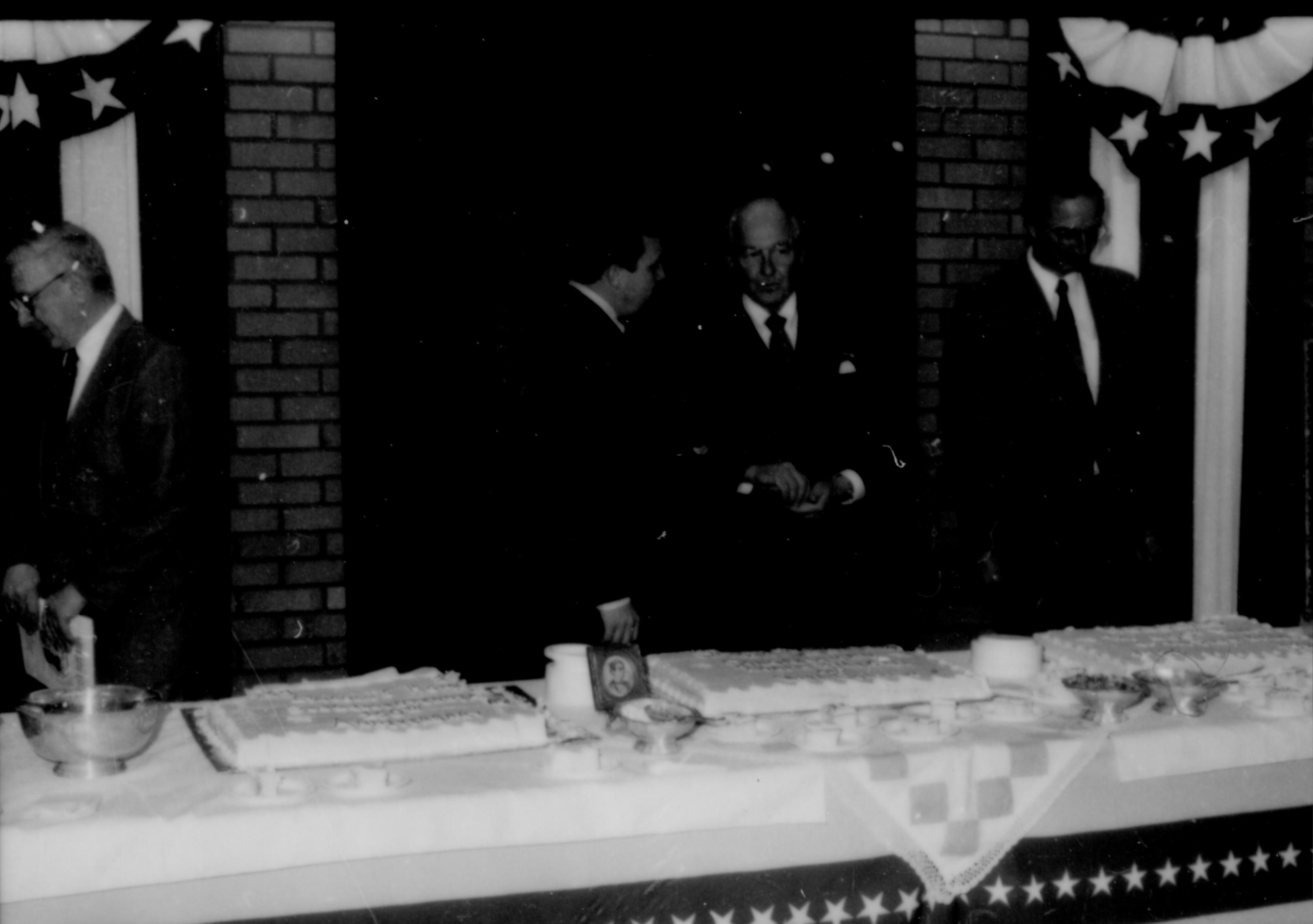 Men standing behind table. Lincoln Home NHS- Paul Findley and Michel VIP visit, 119 Finley, Michel, visit, reception