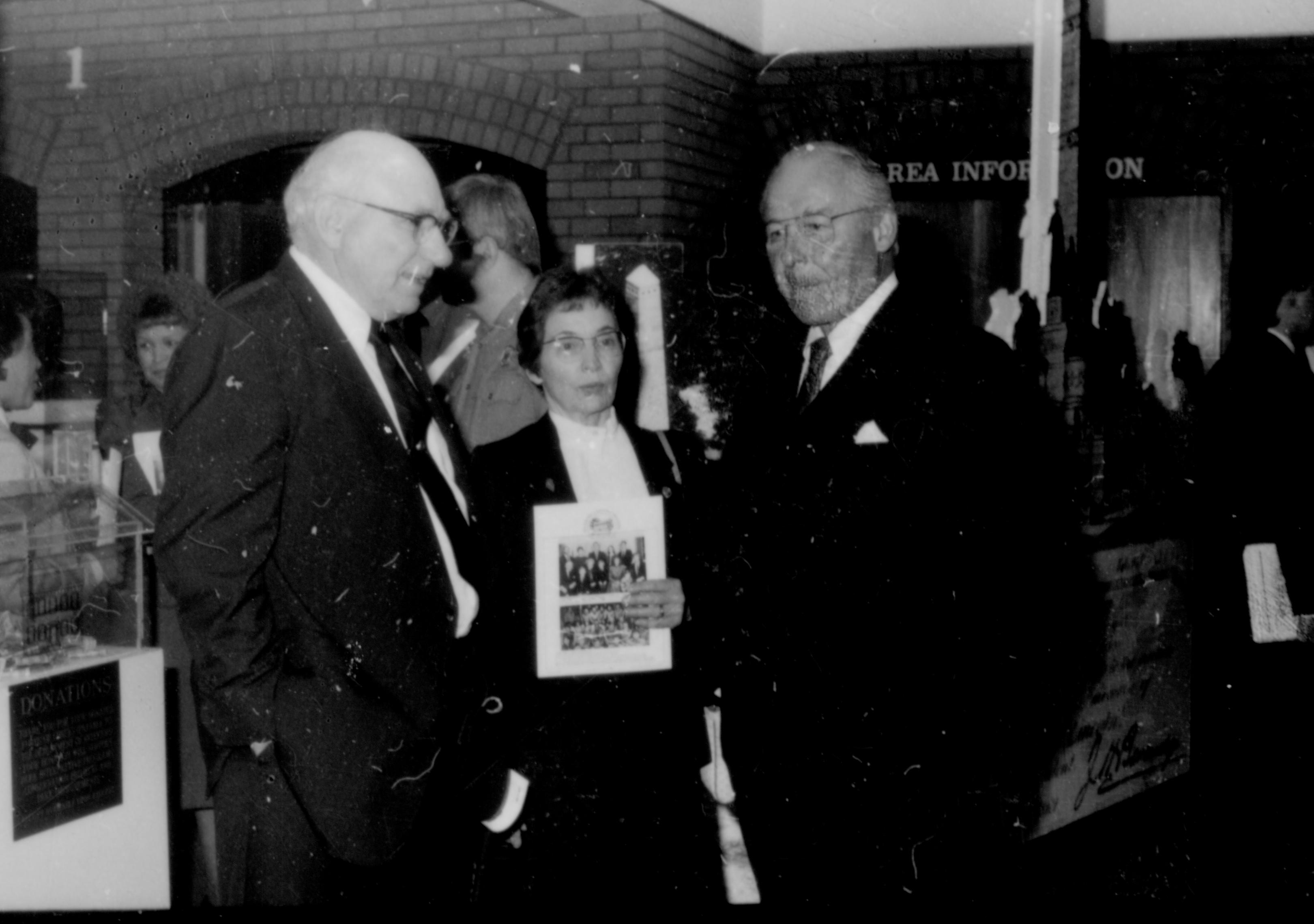 Three people standing, woman holding booklet. Lincoln Home NHS- Paul Findley and Michel VIP visit, 119 Finley, Michel, visit, reception