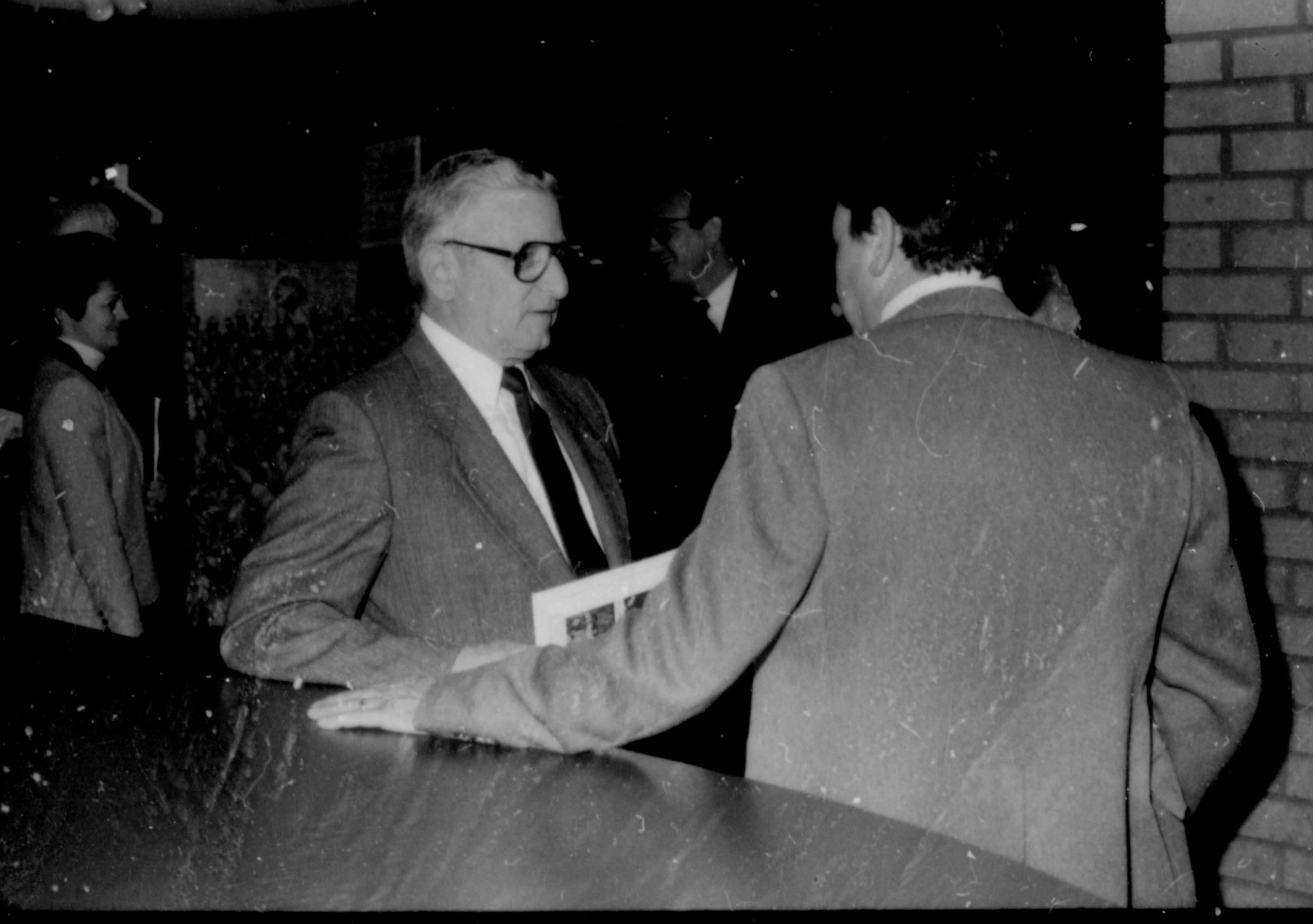 Two men conversing at counter. Lincoln Home NHS- Paul Findley and Michel VIP visit, 119 Finley, Michel, visit, reception