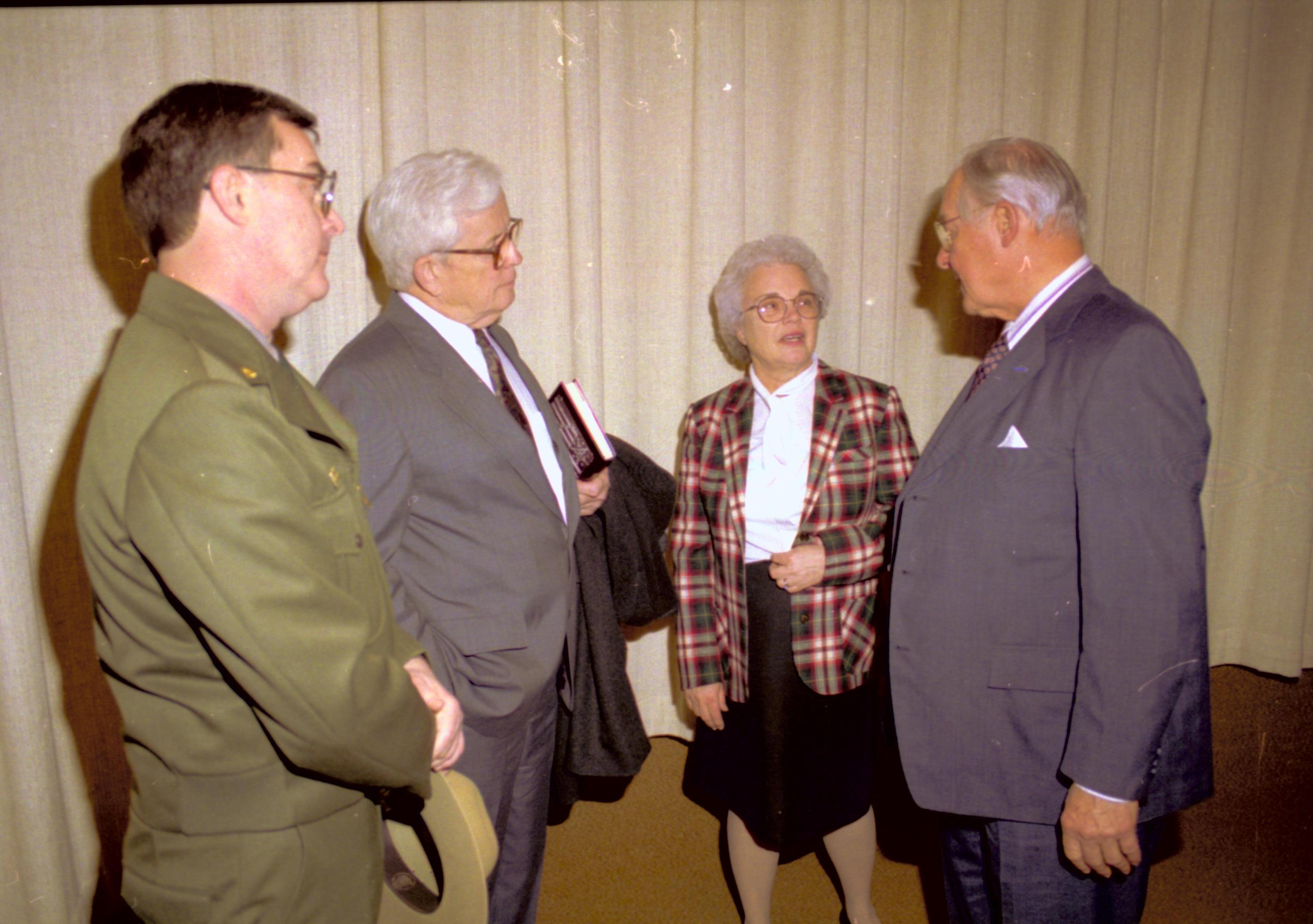 Four people standing in front of theater curtain, talking. Lincoln Home NHS- VIP Findley and Michel Visit to Lincoln Home visit, program