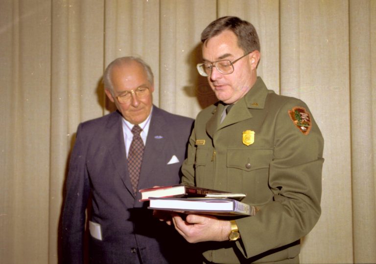 Ranger and man talking in front of curtain. Lincoln Home NHS- VIP Findley and Michel Visit to Lincoln Home visit, program