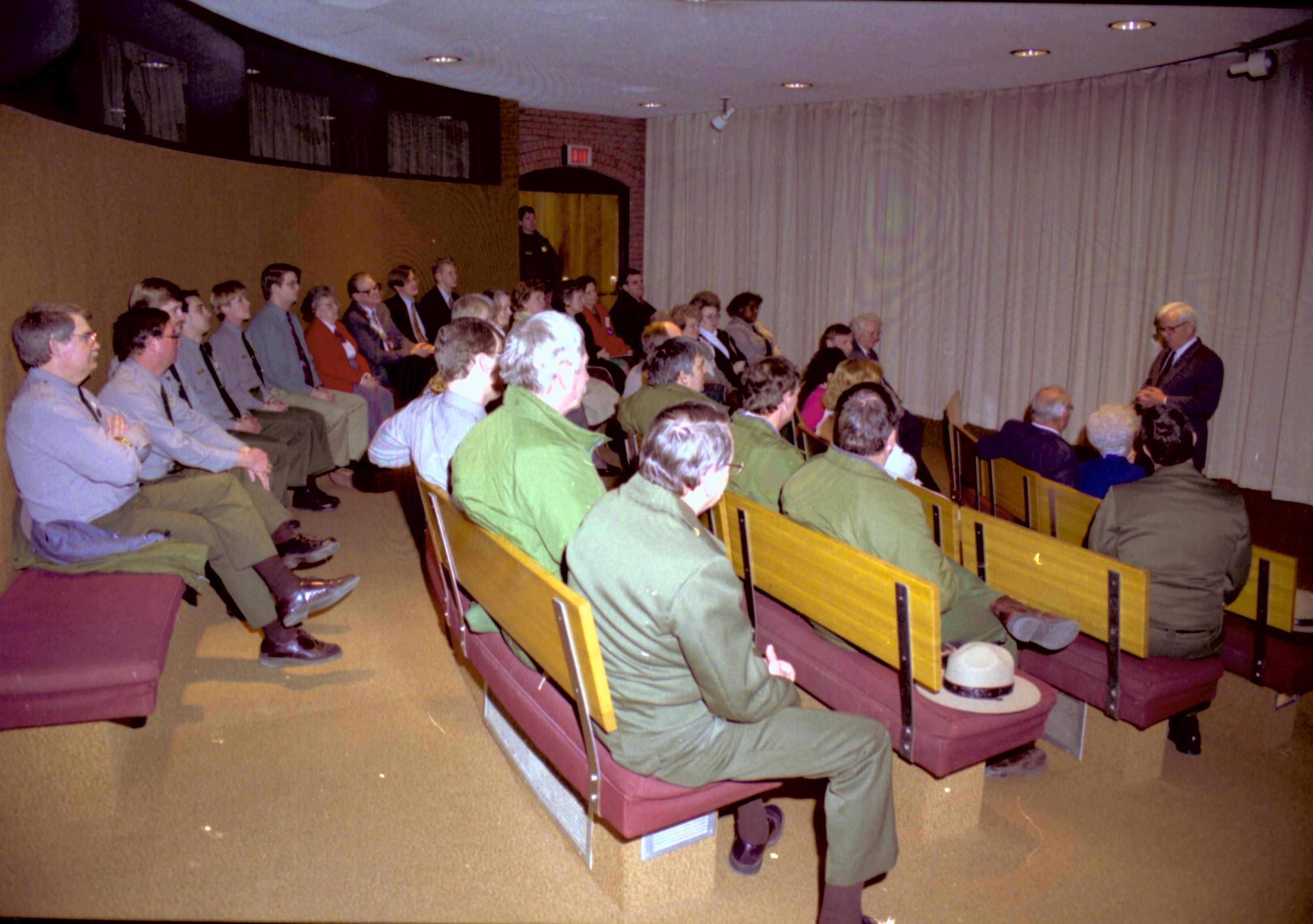 People sitting on benches in theater listening to speaker. Lincoln Home NHS- VIP Findley and Michel Visit to Lincoln Home visit, program