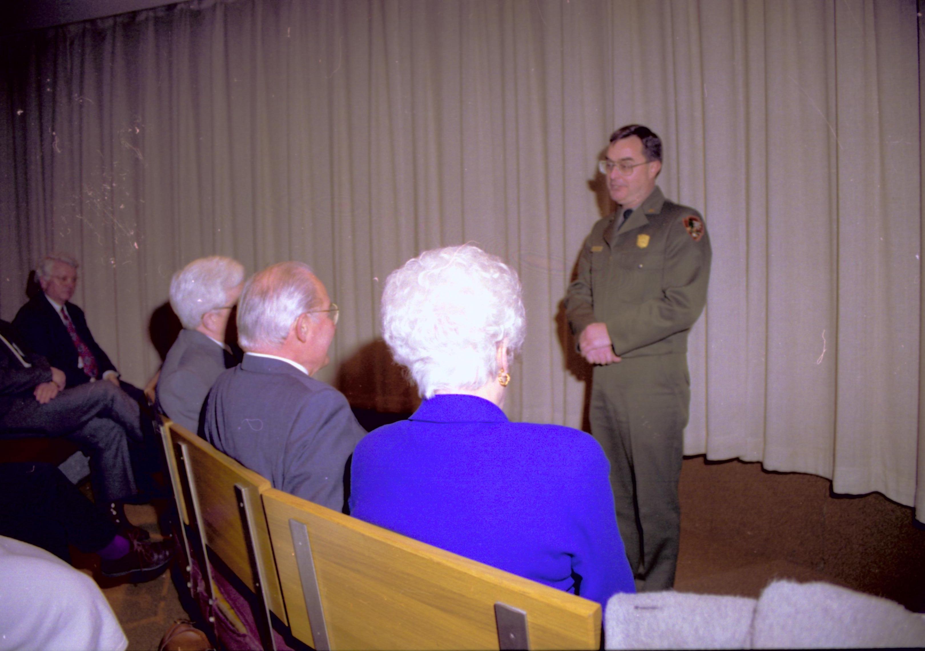 People sitting on benches in theater listening to speaker. Lincoln Home NHS- VIP Findley and Michel Visit to Lincoln Home visit, program