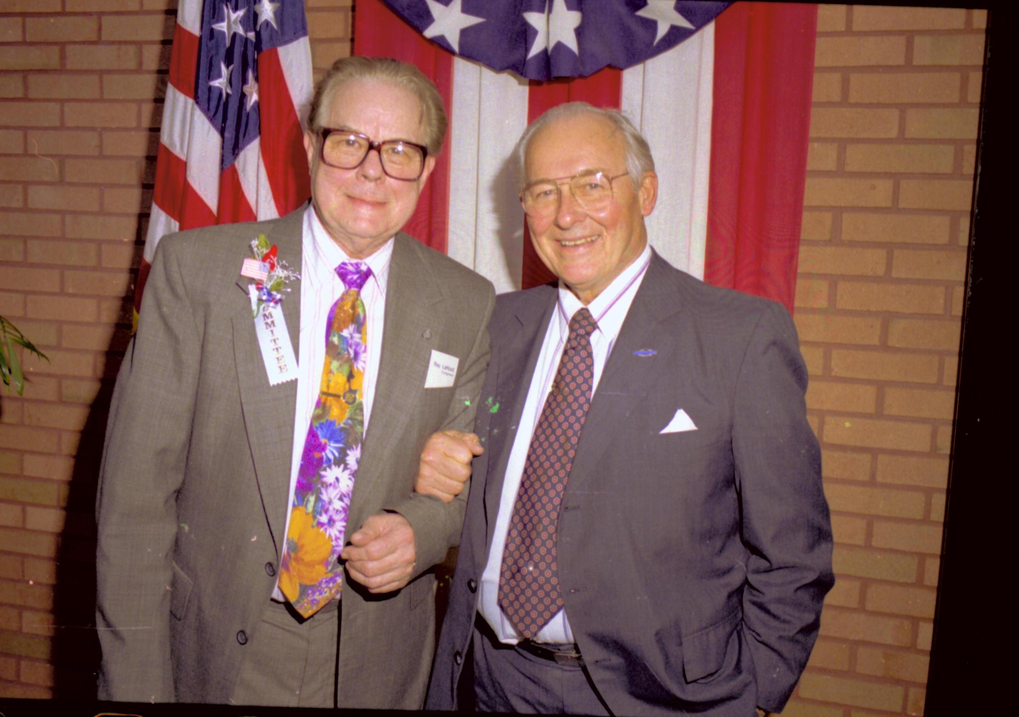 Two men standing in front of flag and bunting. Lincoln Home NHS- VIP Findley and Michel Visit to Lincoln Home visit, program