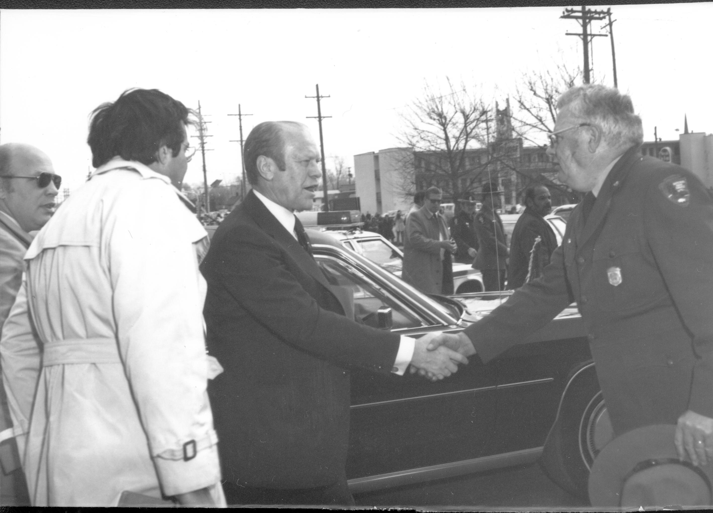 Two men shaking hands by auto. Lincoln Home NHS- President Ford and Visitor Center Corner Stone President, Ford, visit