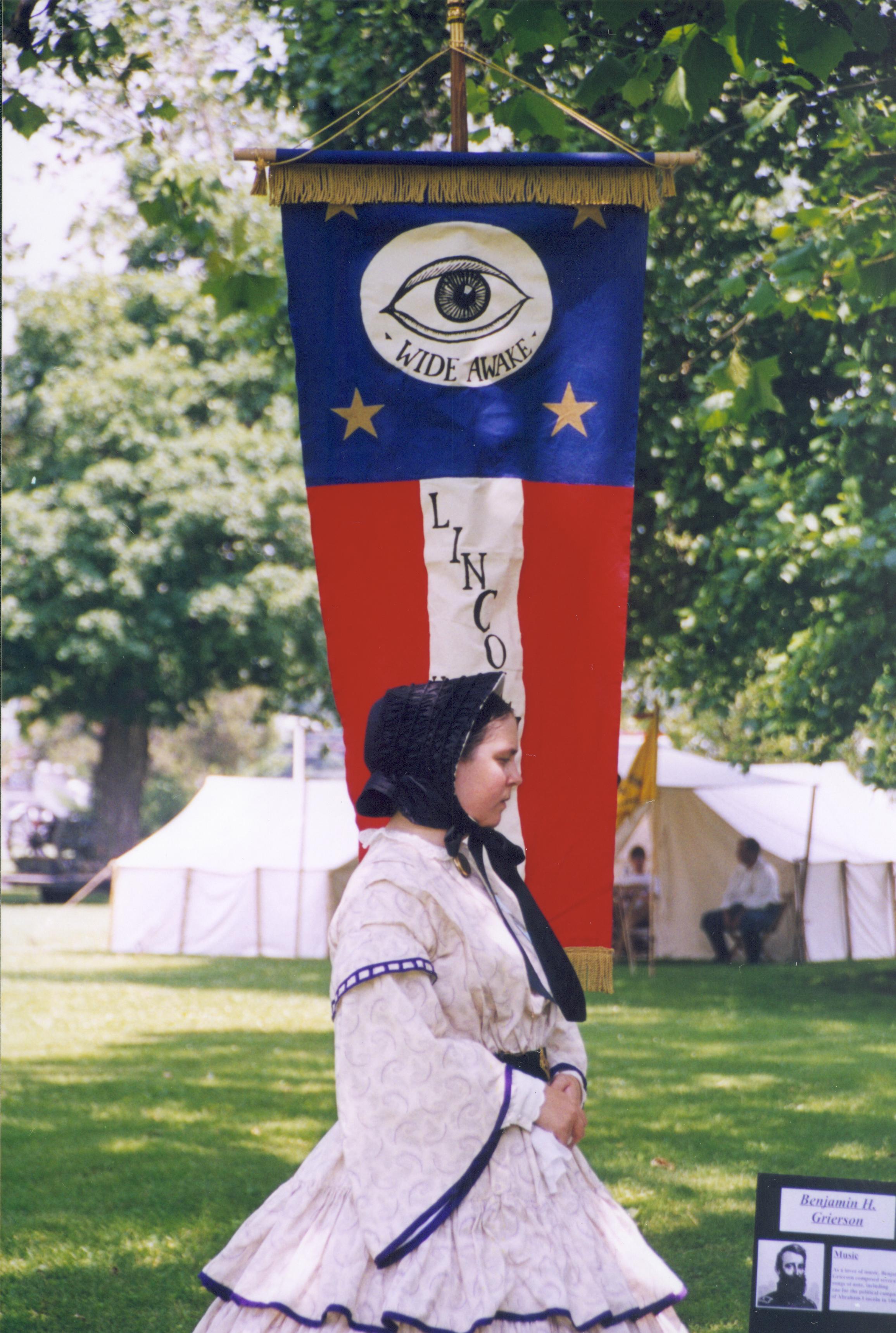 Lady in period dress standing in front of banner. Lincoln Home NHS- Grierson Days Jacksonville Grierson, Jacksonville, celebration