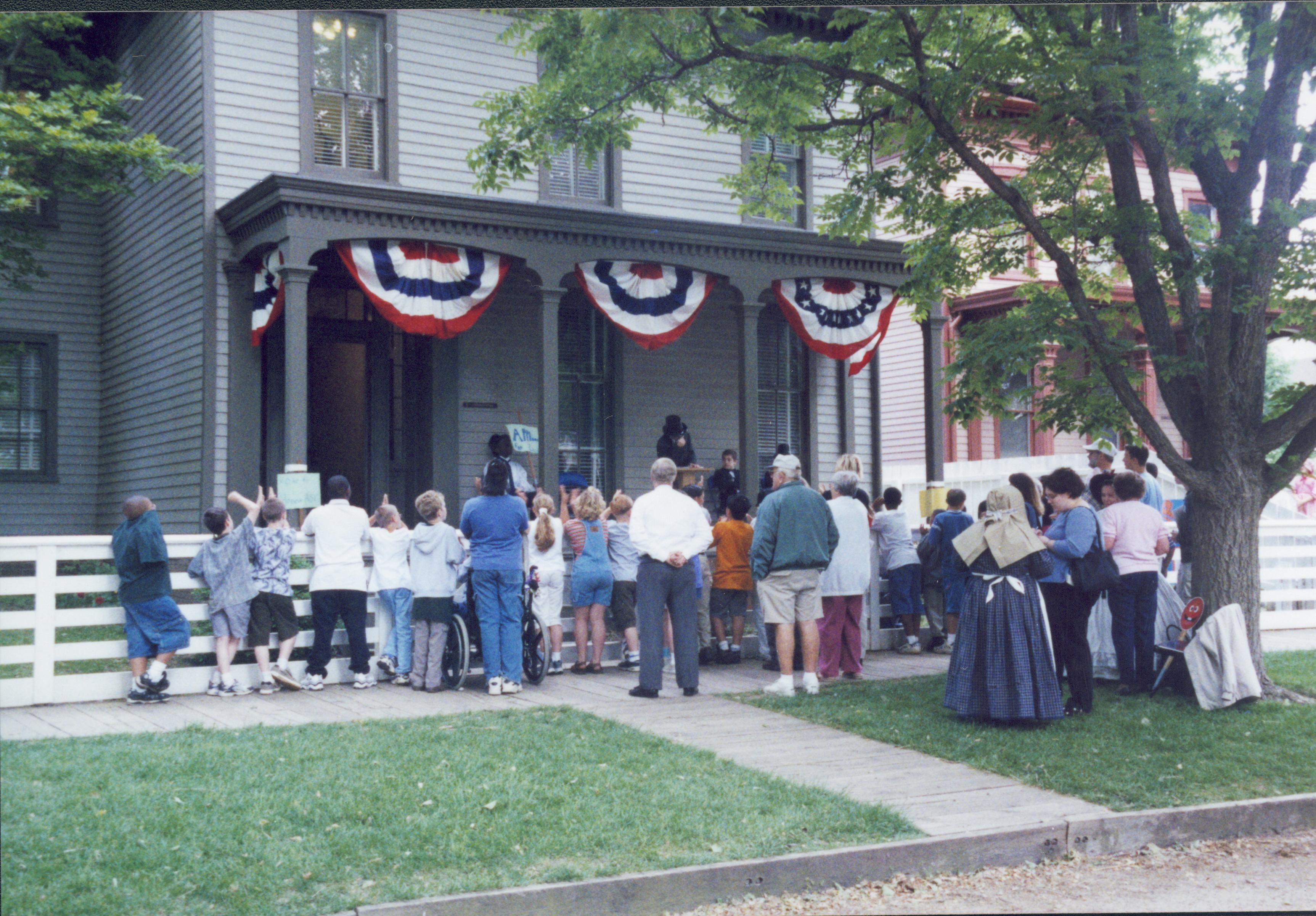 Iles School Living History program - Lincoln-Douglas debates performed by students on the Lyon House porch while school groups, parents, and teachers (in period clothing) watch.  Beedle House visible on right. Looking Northeast from 8th Street Iles School, living history, Lincoln-Douglas debates, students, school groups