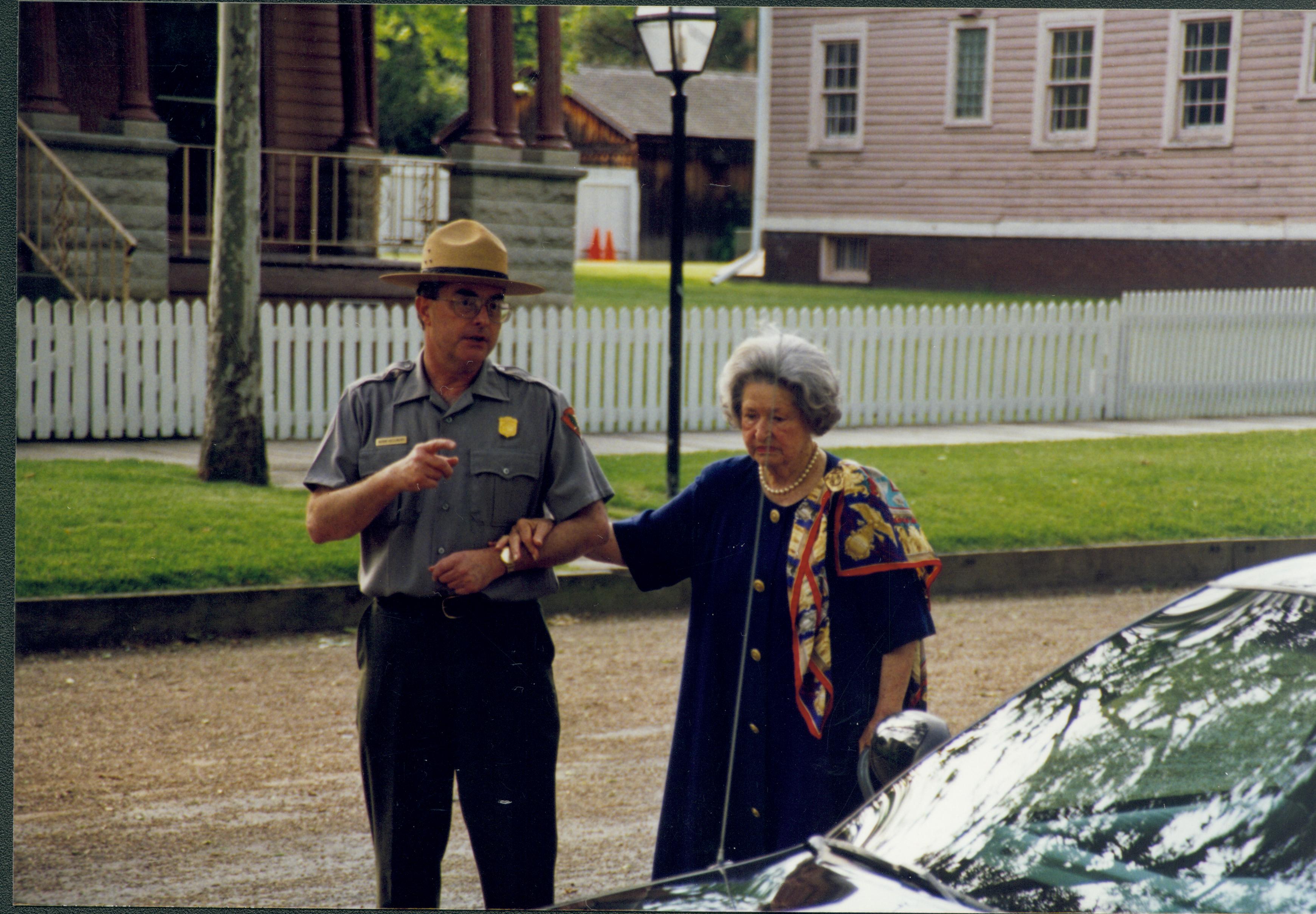 Ranger talking and walking with lady in street. Lincoln Home NHS- Lady Bird Johnson visit, roll #1 neg #24 Johnson, visit, tour