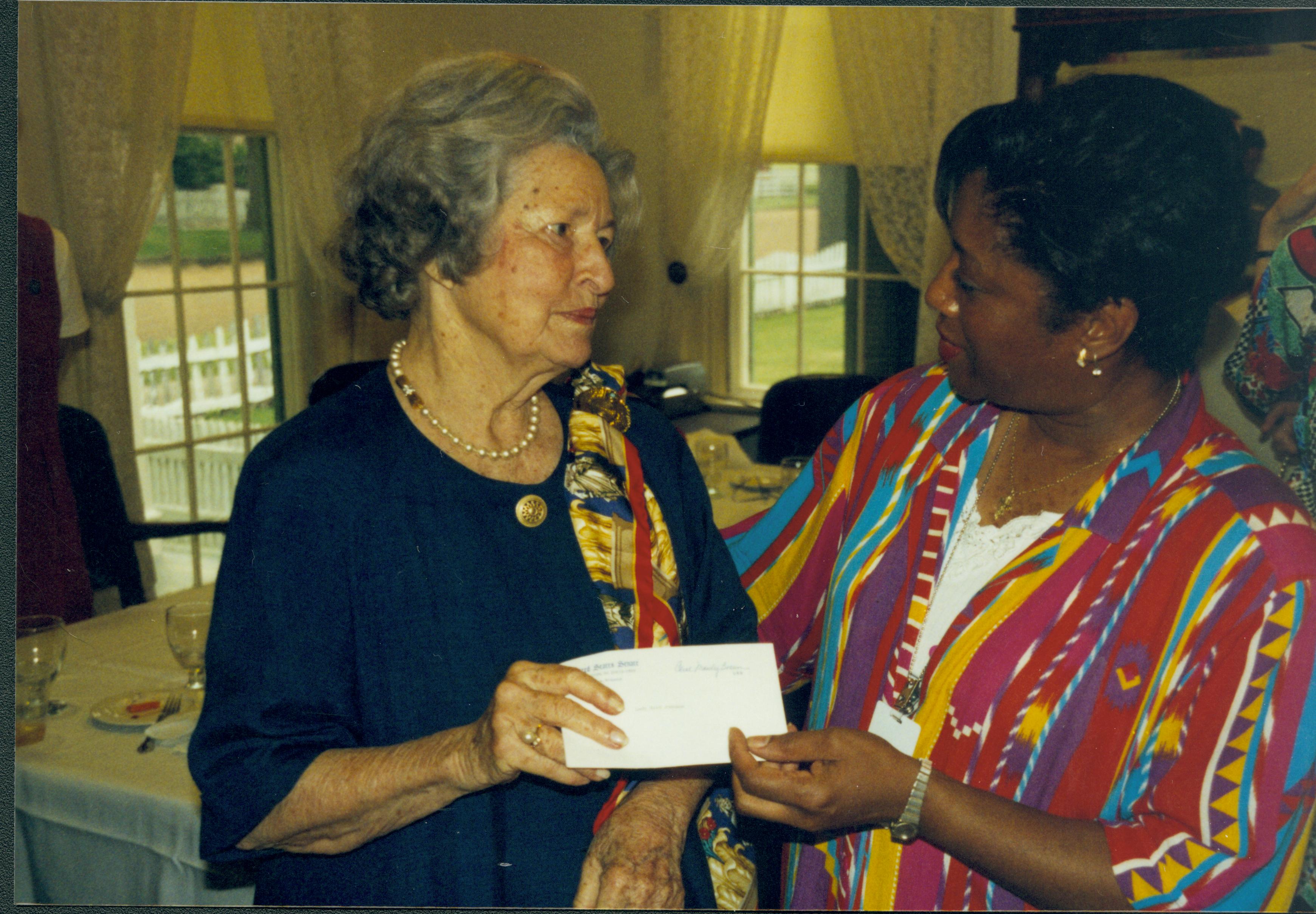 Lady handing envelope to another lady. Lincoln Home NHS- Lady Bird Johnson visit, roll #2 neg #2 Johnson, visit, tour