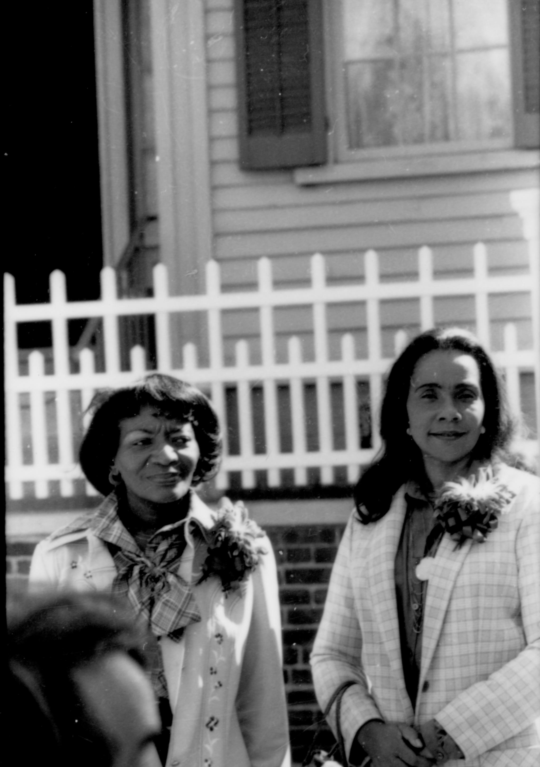 Two ladies standing by Lincoln fence. Lincoln Home NHS- Coretta King Visit King, visit