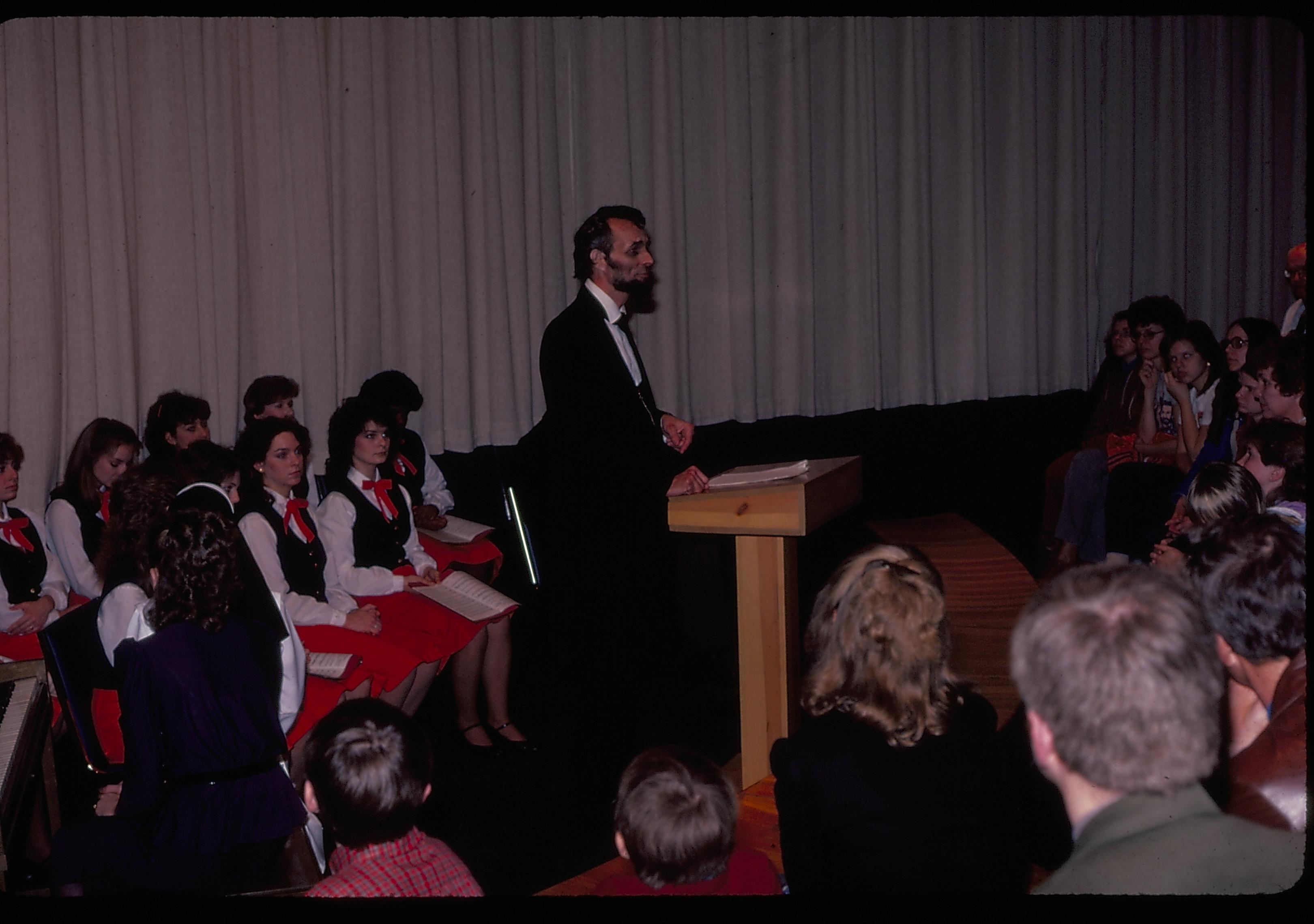 Lincoln impersonator speaking from podium. choral group seated behind. Lincoln Home NHS- Lincoln's Birthday 1984 birthday, Lincoln