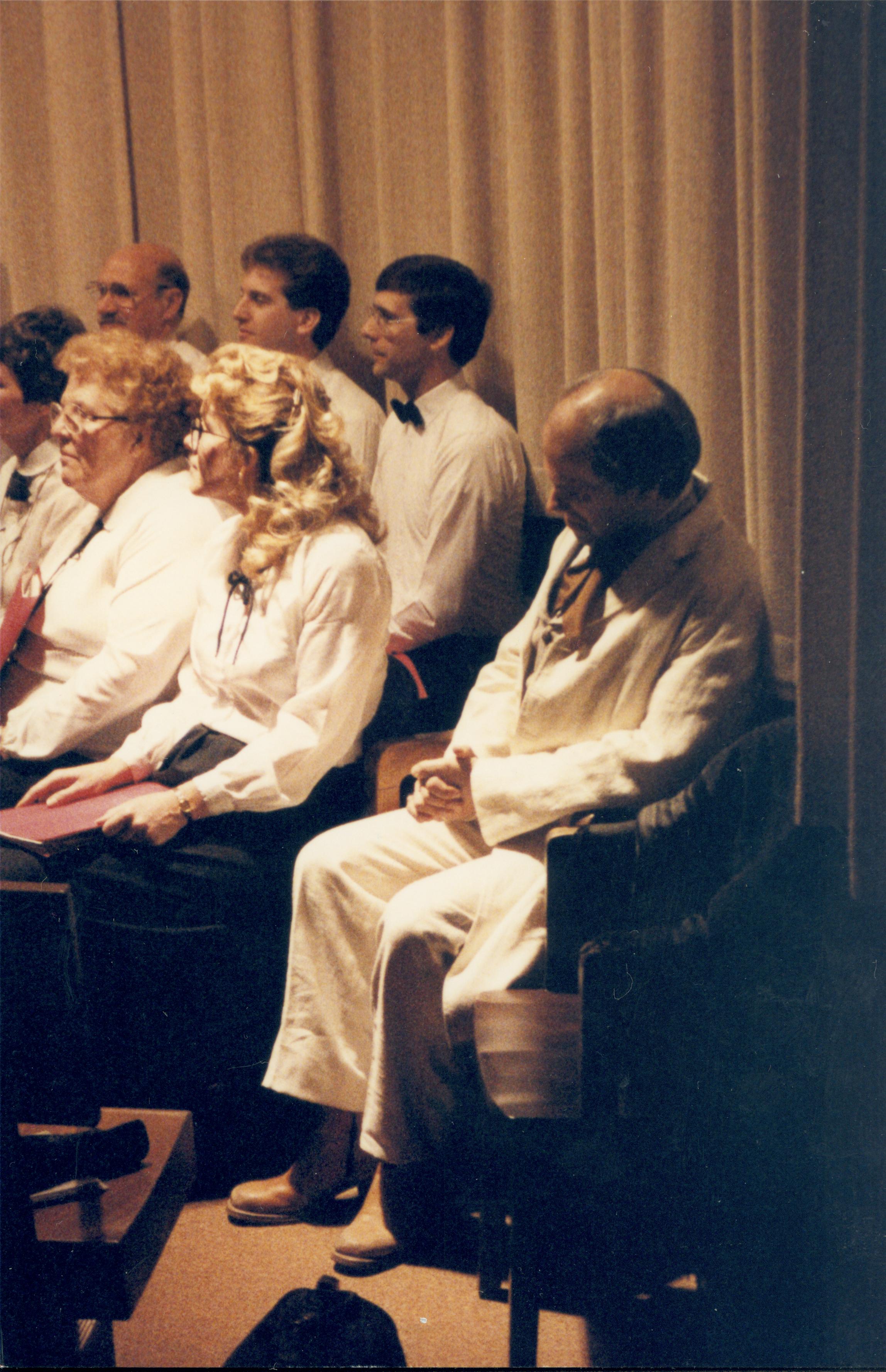 Choir and person in period dress seated in front of curtain. Lincoln Home NHS- Lincoln's Birthday 1988 birthday, Lincoln, Douglas