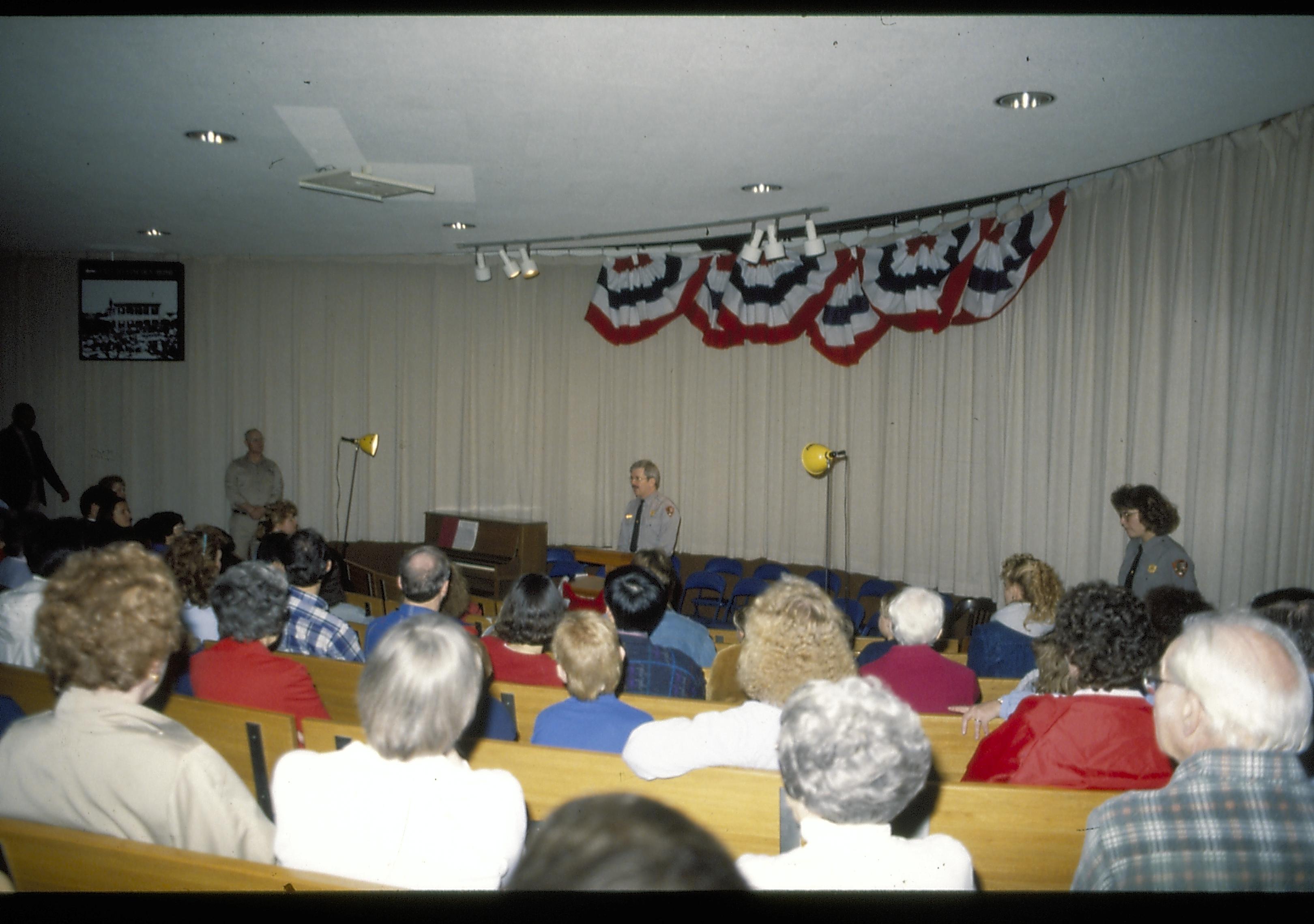 Ranger speaking from podium in theater one. Lincoln Home NHS- Lincoln's Birthday 1988 birthday, Lincoln, Douglas